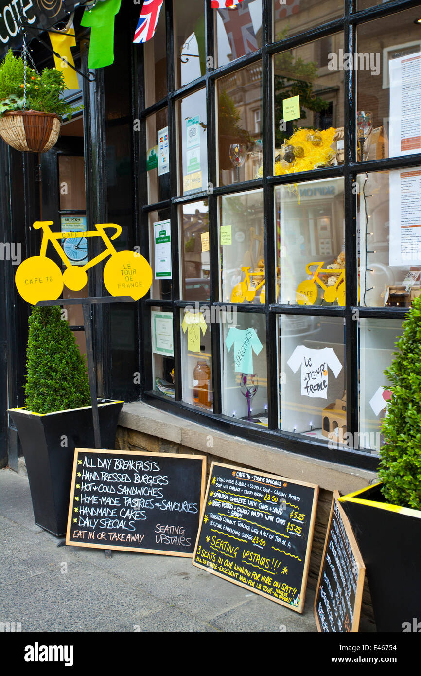 Tiendas decoradas en Skipton para celebrar el Tour de Francia. Miles de ciclistas han estado en los valles de Yorkshire recorriendo la ruta del Grand Depart. Los caminos y campos asignados al estacionamiento y acampada están empezando a llenarse en preparación para el evento del sábado. El Tour de Francia es el evento deportivo anual más grande del mundo. Es la primera vez que Le Tour ha visitado el norte de Inglaterra, ya que anteriormente sólo había hecho visitas a la costa sur y a la capital. Foto de stock