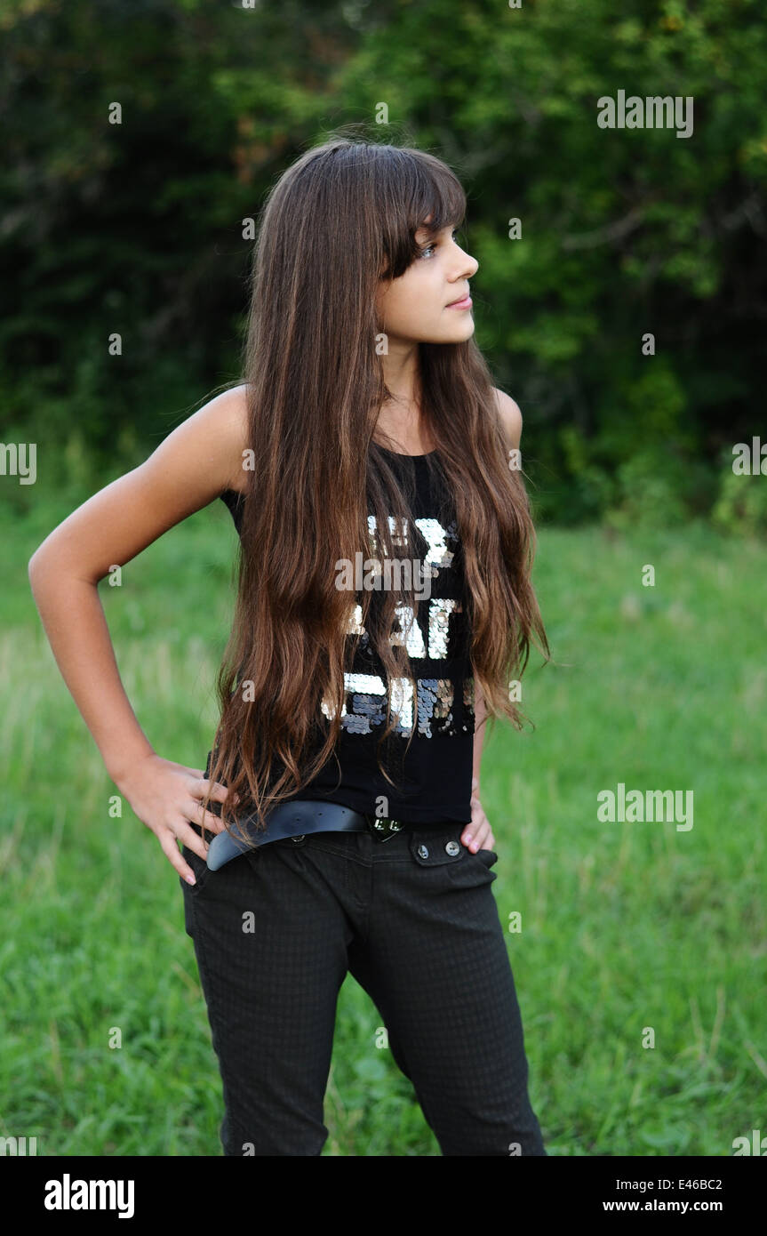 Girl teen adolescente de 13 a 14 la edad de transición de 15 años morena  cabello largo y oscuro de la naturaleza al aire libre del parque bello  retrato camiseta permanente Fotografía