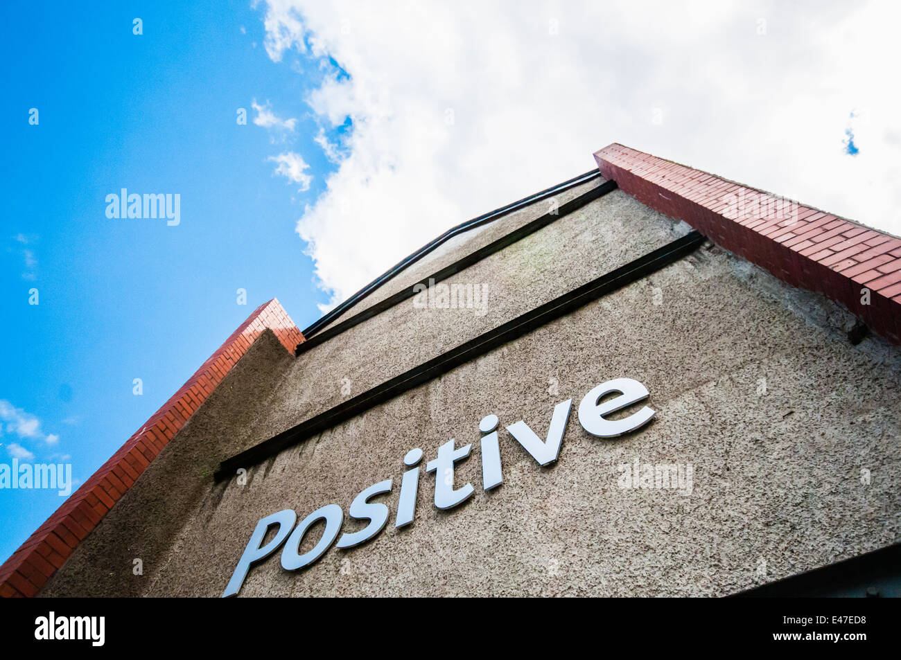 'Positiva' en el lateral de un edificio apuntando hacia el cielo. Foto de stock