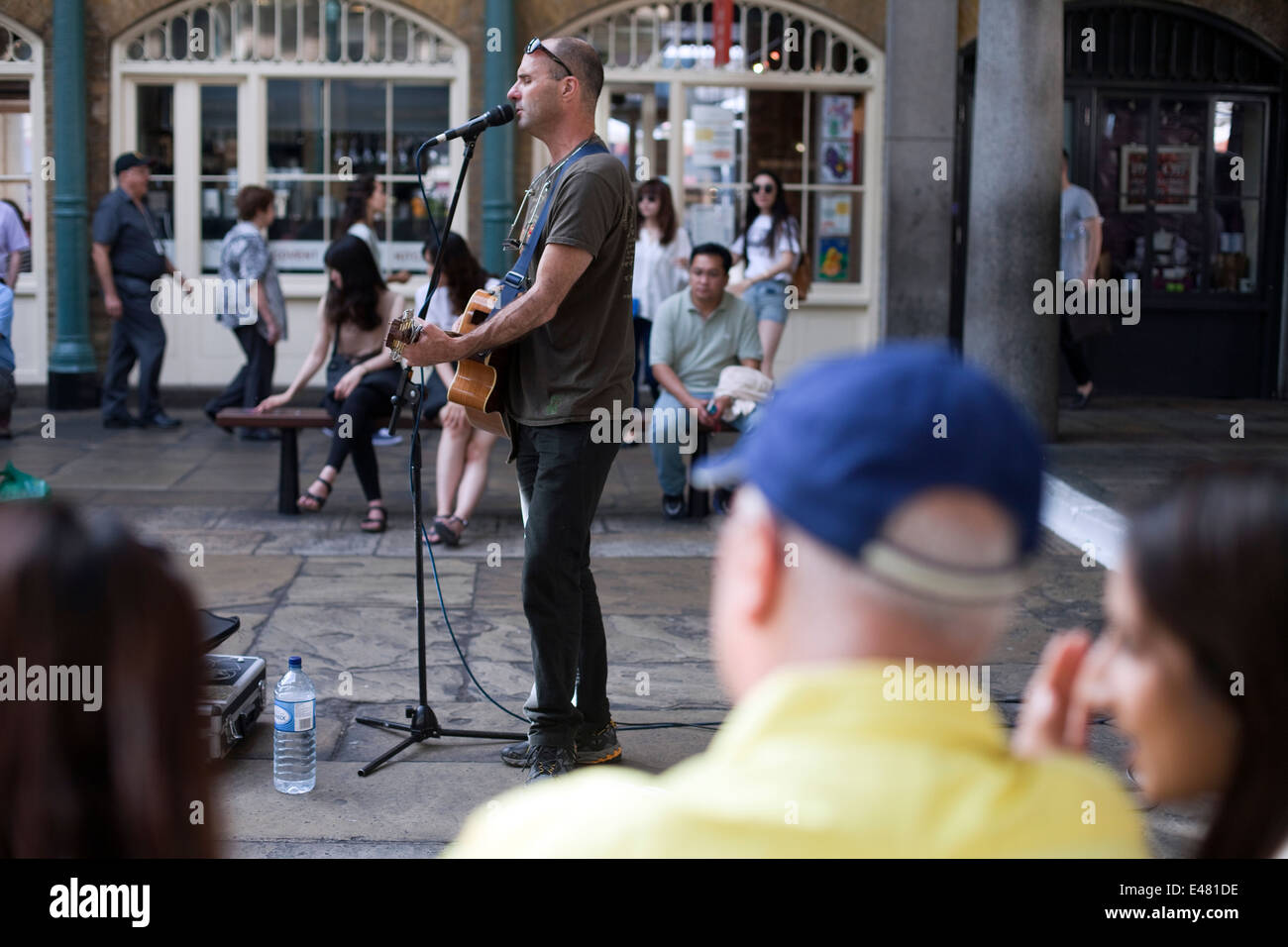 Un músico canta y toca la guitarra a una audiencia en el mercado de Covent Garden Piazza. Londres, Reino Unido Foto de stock