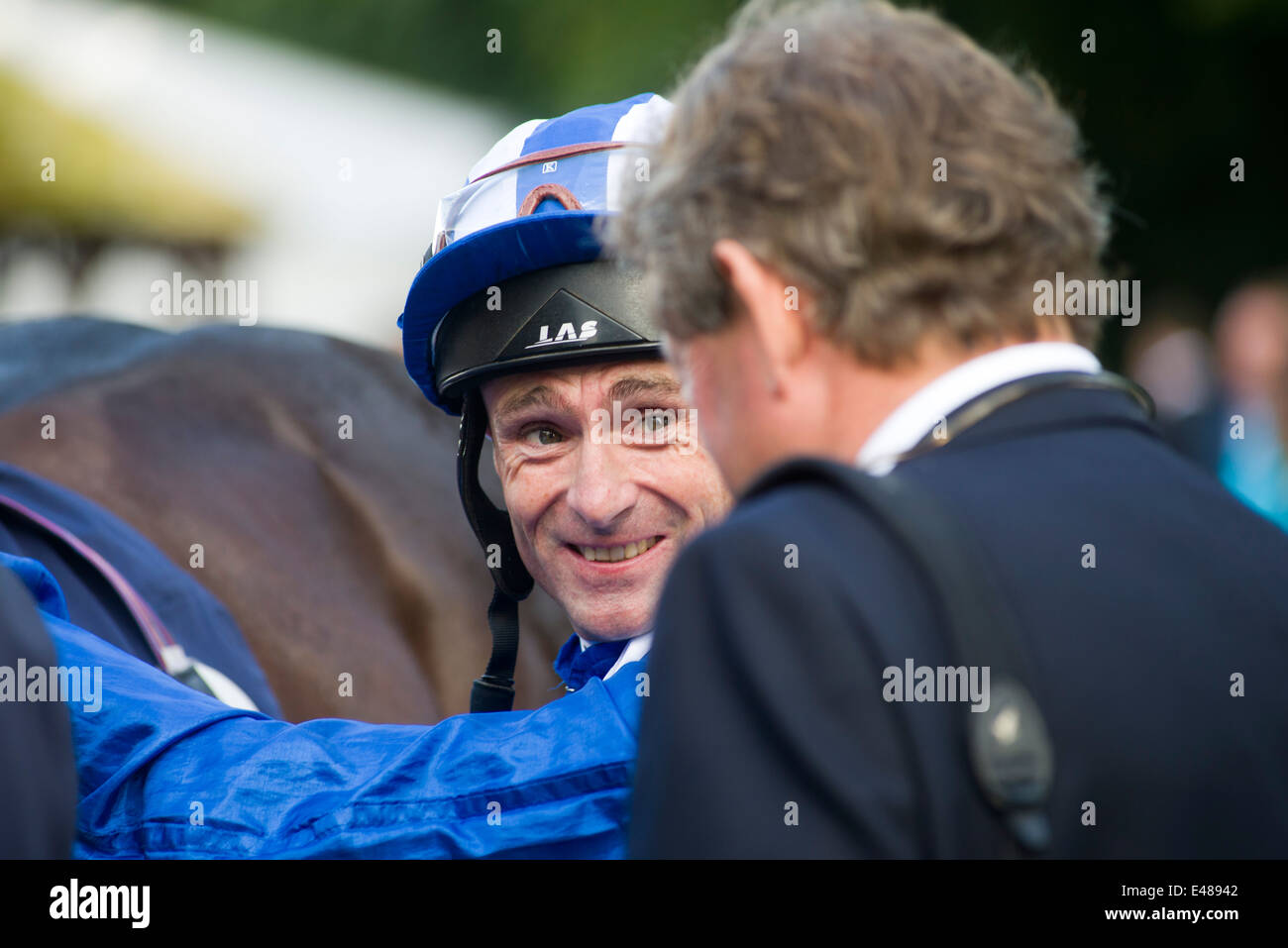 Jockey Dane O'Neil conversaciones al instructor, sonriendo Foto de stock