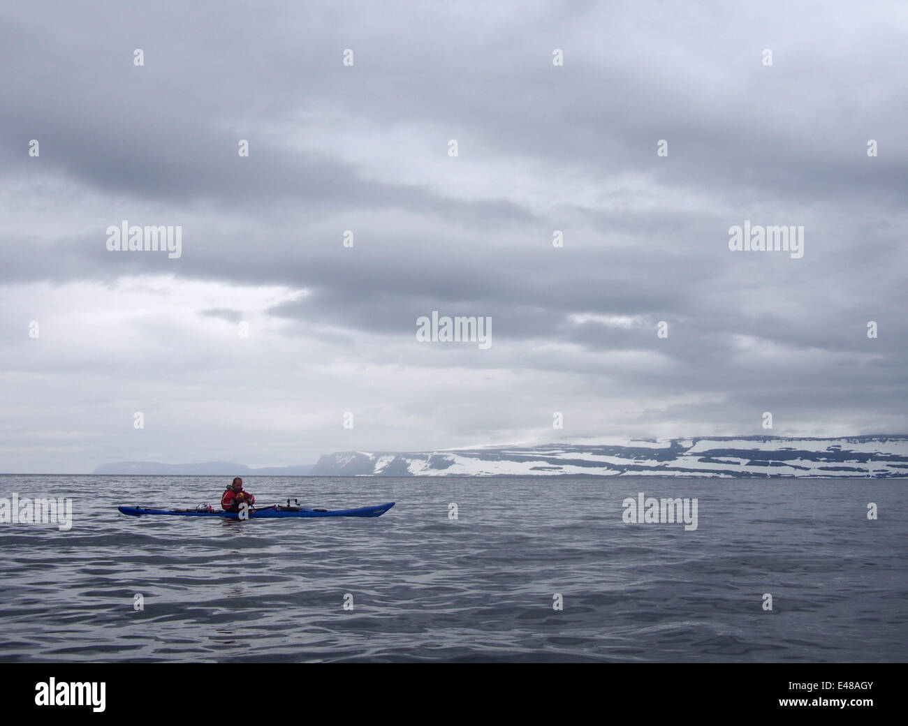La pesca desde kayak de mar cerca de Folafótur, fiordos del oeste, Islandia Foto de stock
