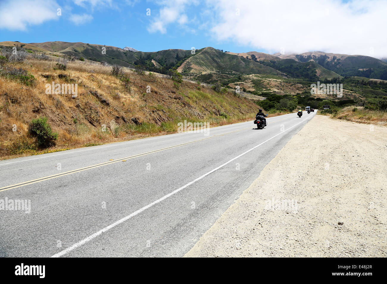 Biker cabalgando por la Ruta 1, Autopista del Pacífico de California, en el camino de Big Sur, con impresionantes vistas del océano Foto de stock
