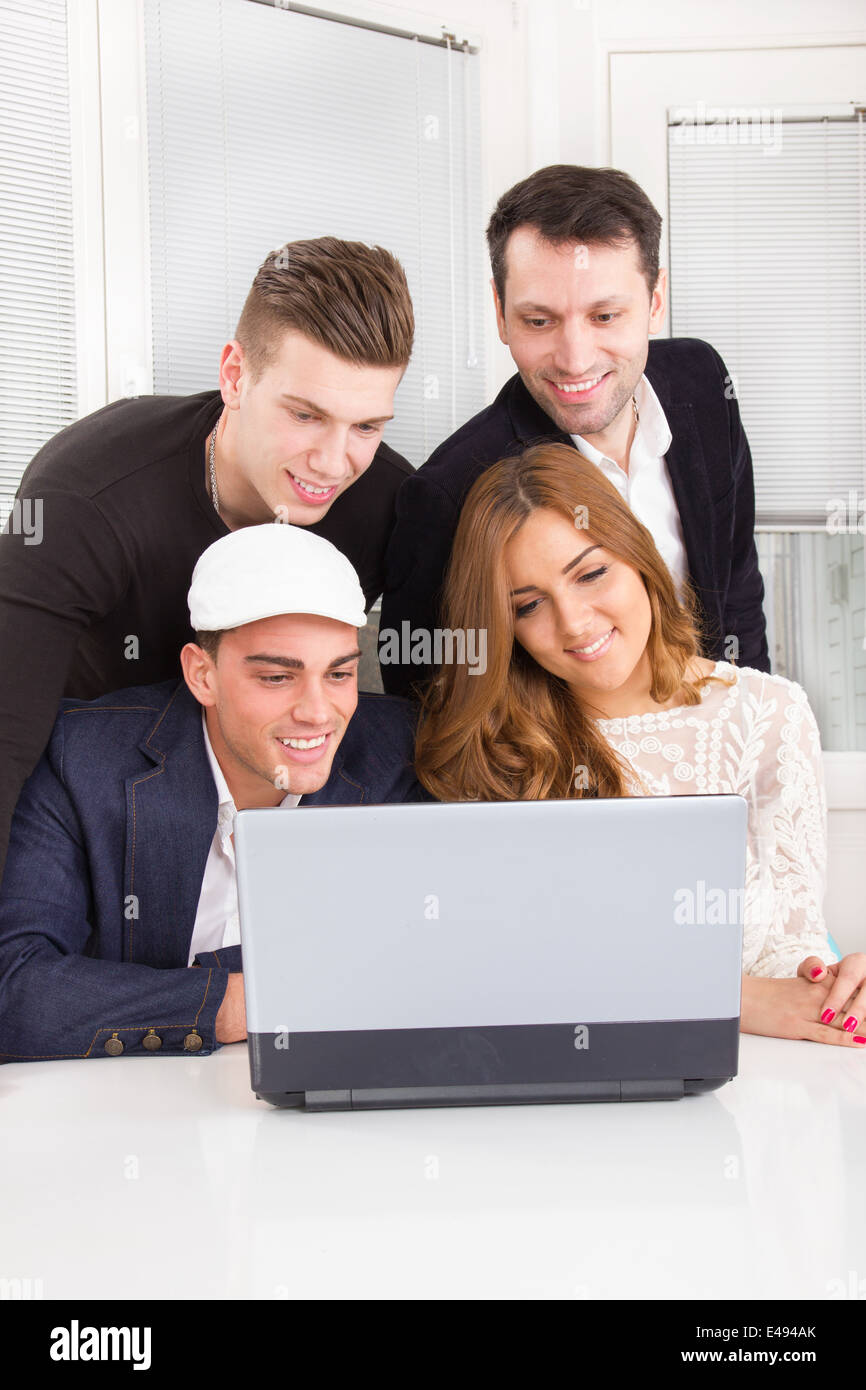 Hermoso grupo de amigos y colegas mirando juntos sonriendo portátil Foto de stock