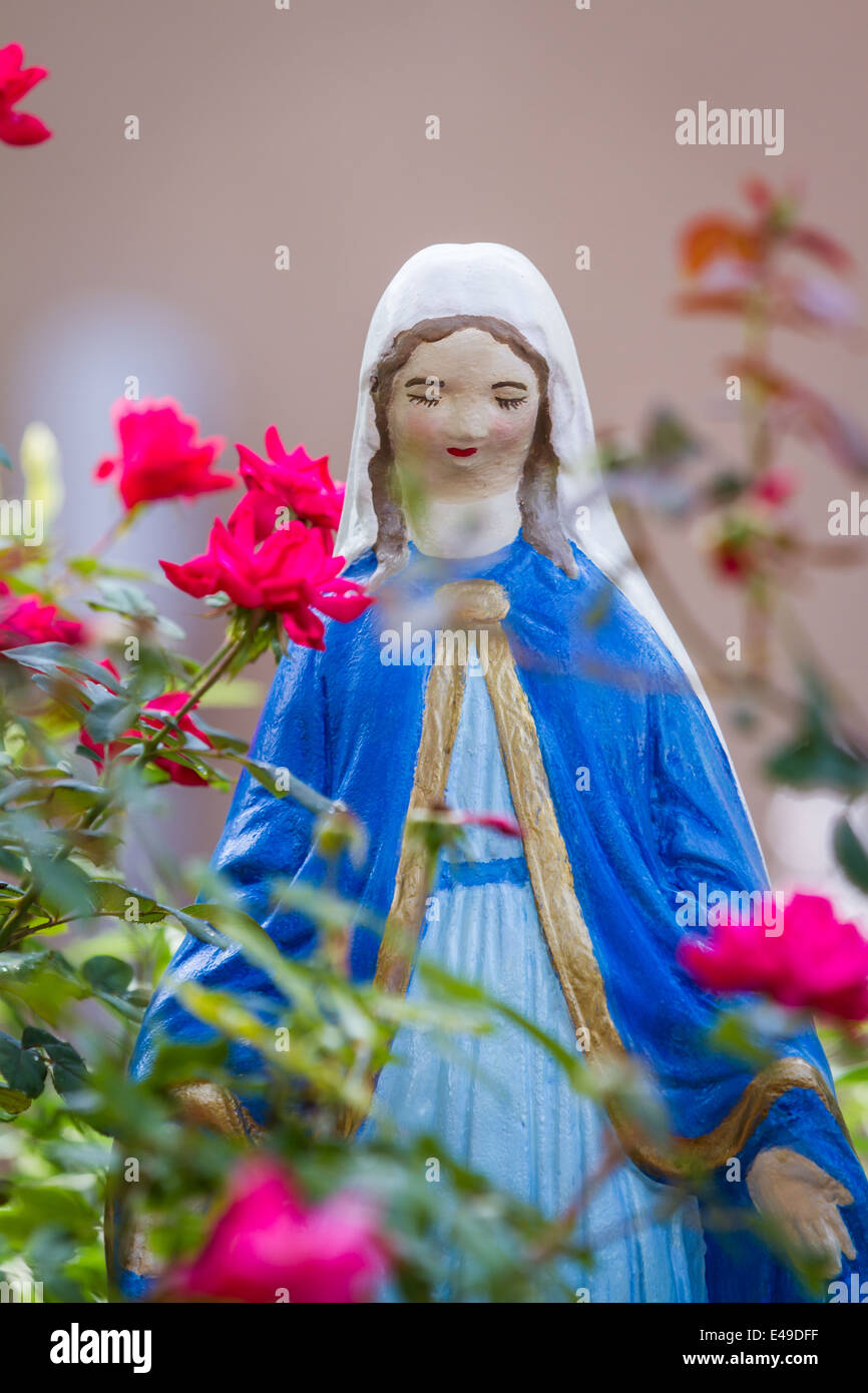 Simbolo Religioso De La Virgen Maria O La Madre Maria Como Decoracion De Jardines Con Rosas Rojas Que Lo Rodea Fotografia De Stock Alamy
