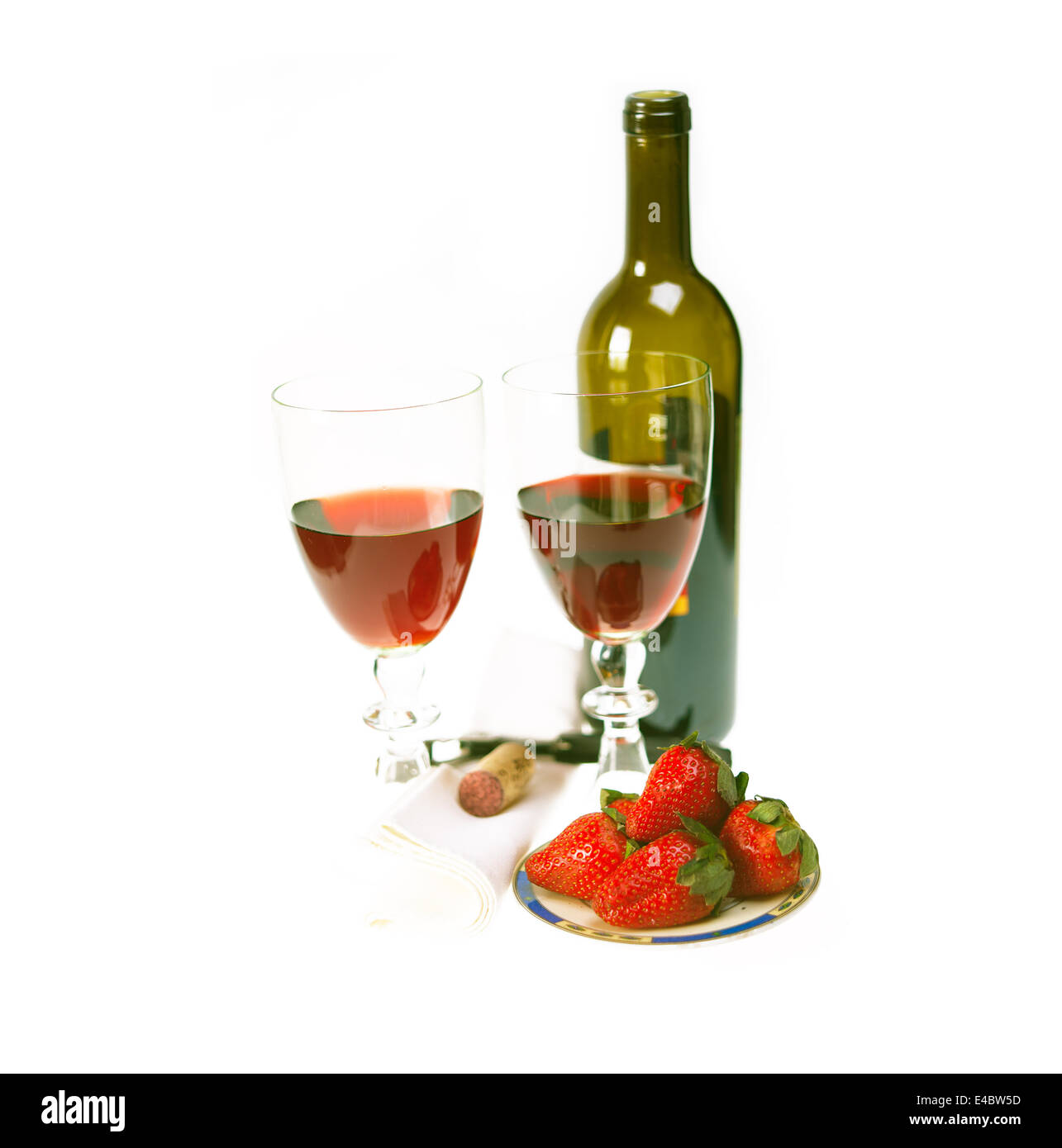 Botella de vino tinto y dos copas con fresas Foto de stock