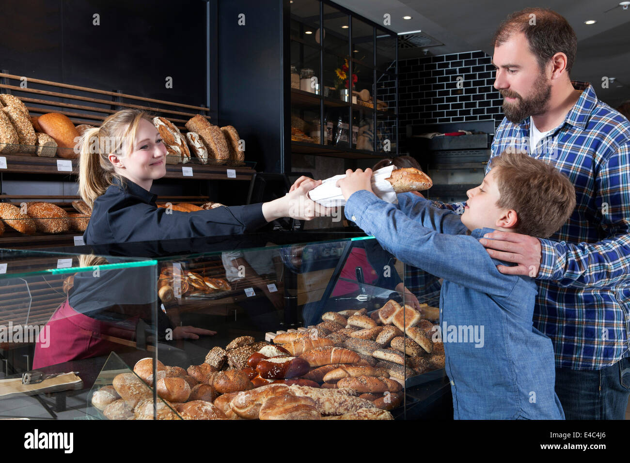El padre y el hijo, comprar el pan en una panadería Foto de stock