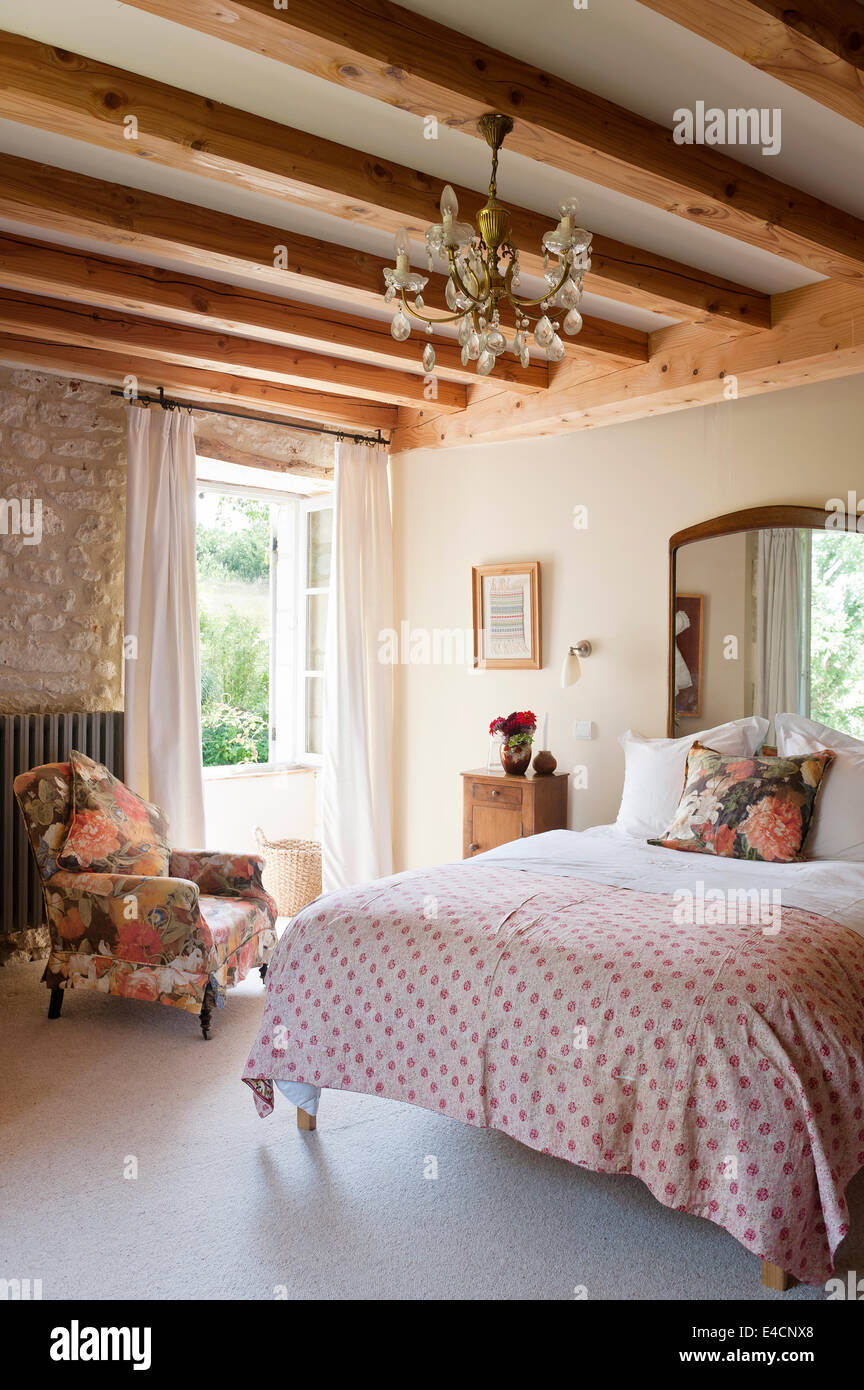Persa antiguo colcha bordada en la cama en el dormitorio, con paredes de  piedra y vigas de madera. El sillón es tapizado en fl Fotografía de stock -  Alamy