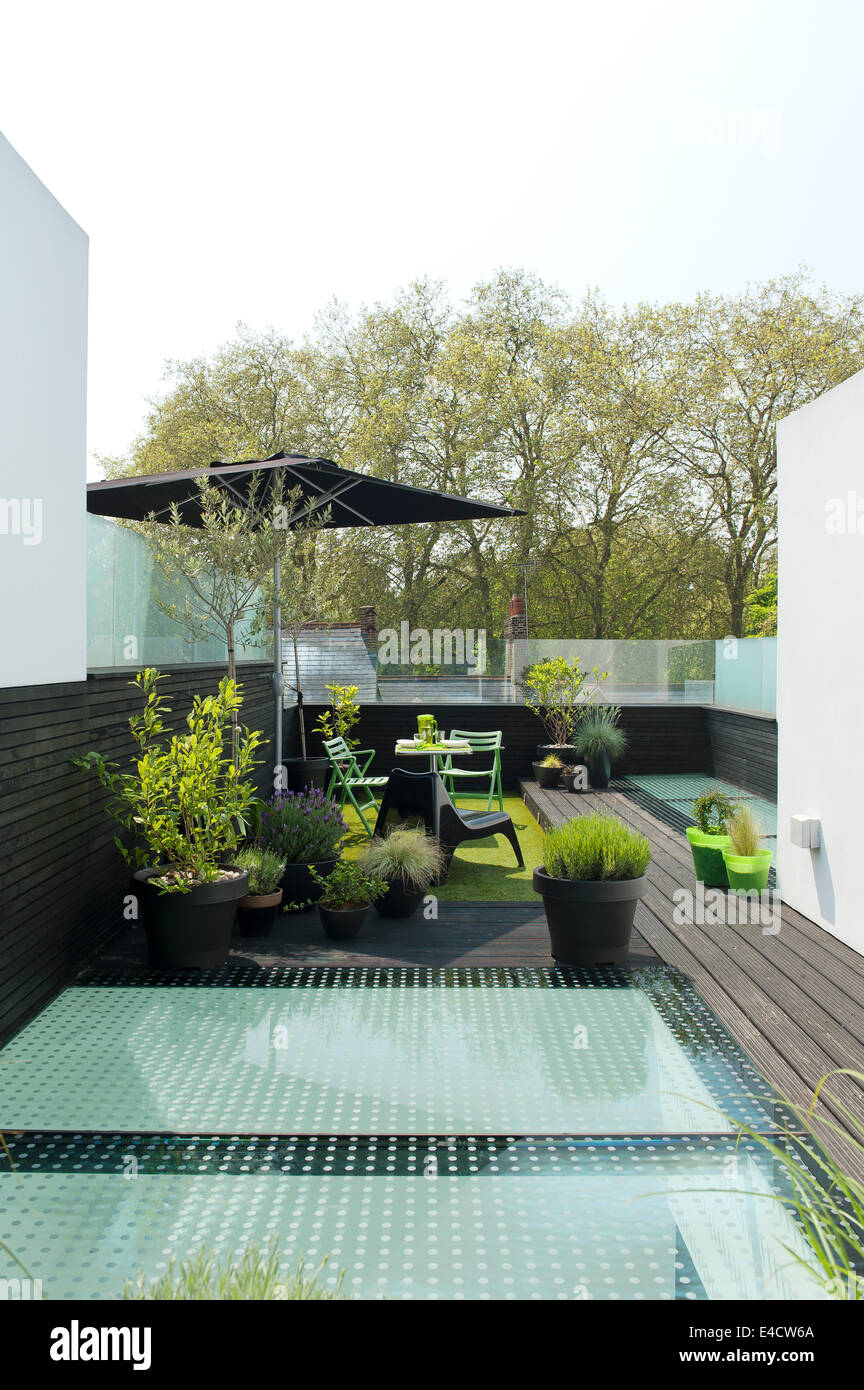 Muebles de jardín y plantas en macetas en la terraza de la azotea moderna Foto de stock