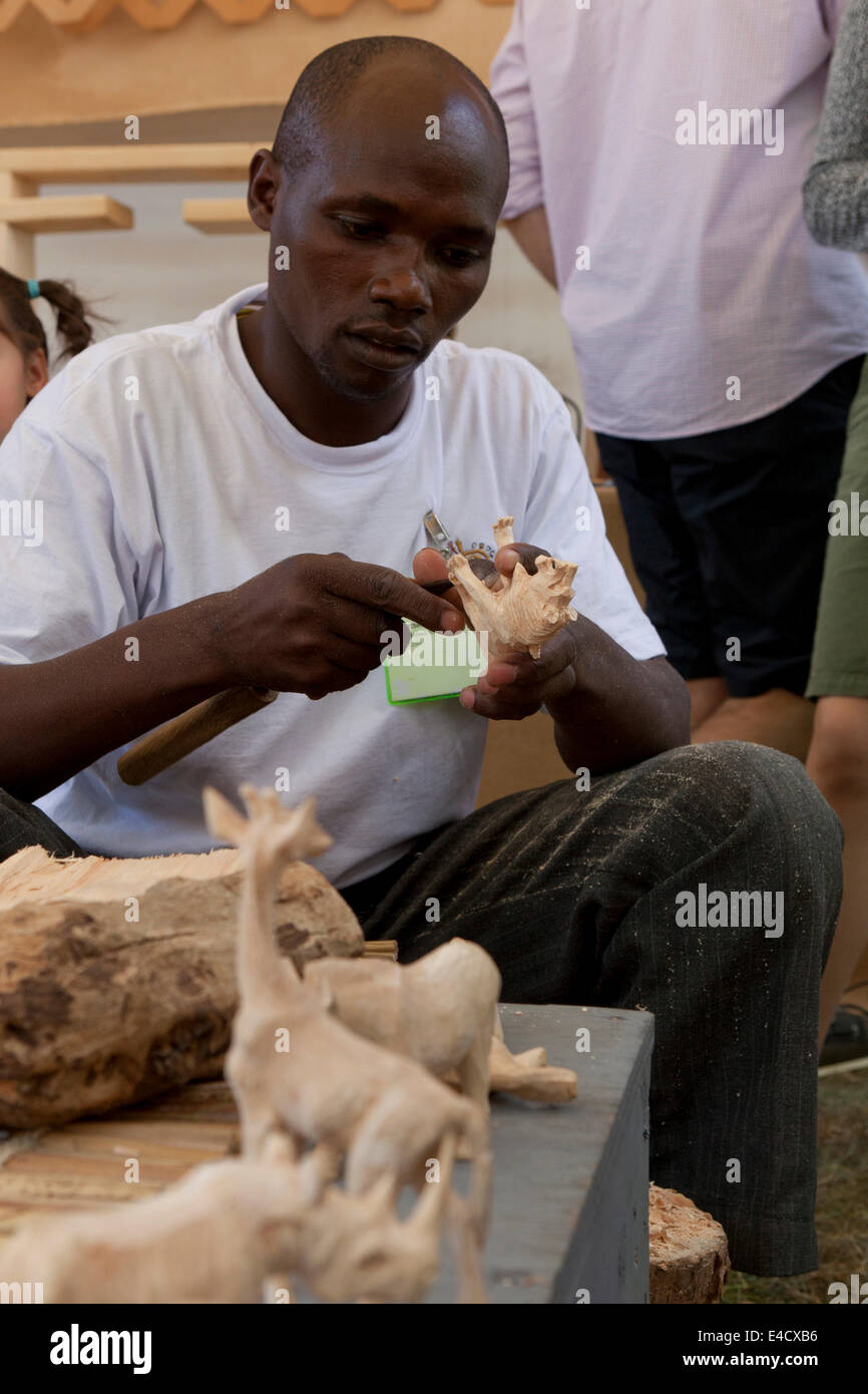 Hombre keniano haciendo animal tallado en madera - EE.UU. Foto de stock