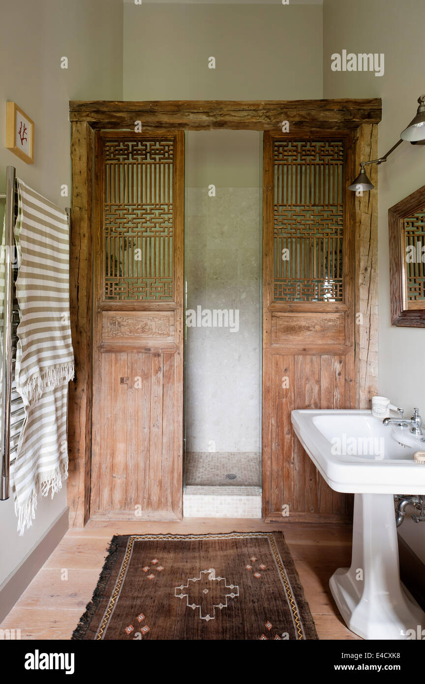 Un par de puertas de madera de la antigua China utiliza como mampara de  ducha en el baño con Aston Matthews lavatorio Fotografía de stock - Alamy