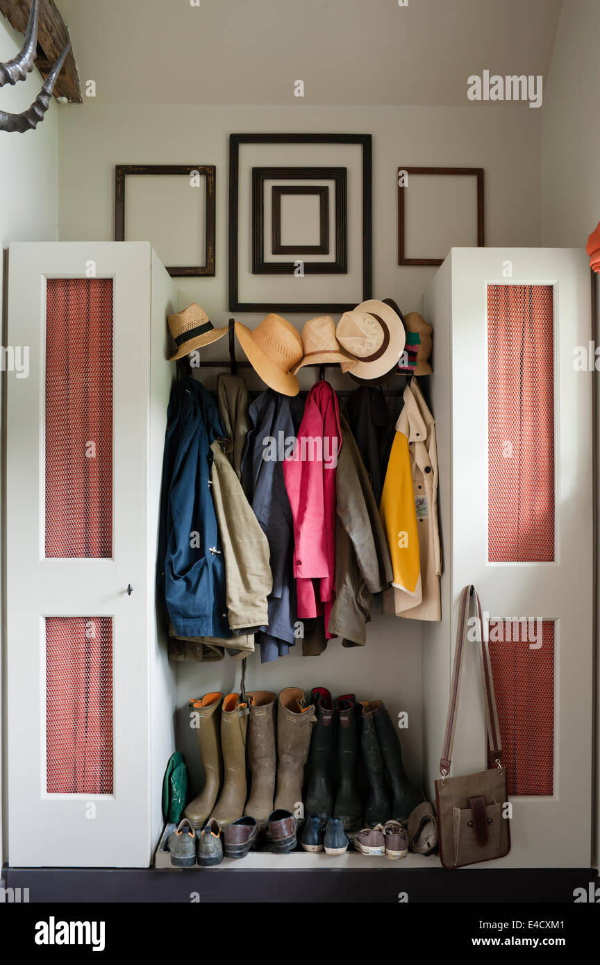 Abrigos, sombreros y botas Wellington en un vestíbulo de entrada con  armarios de almacenamiento Fotografía de stock - Alamy