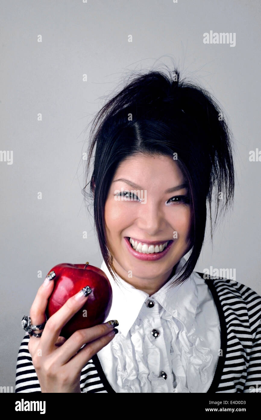 Mujer Asiática la celebración de Apple. Ella es japonesa y fue en sus primeros veinte años en el momento de disparar. Foto de stock