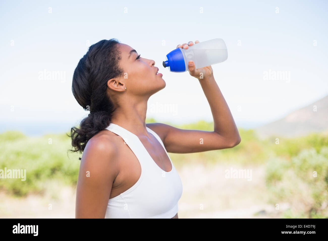 Colocar mujer beber agua de botella de deportes Foto de stock