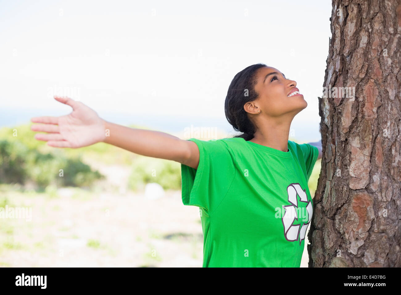 Bastante activista ambiental mirando hacia arriba en el árbol Foto de stock