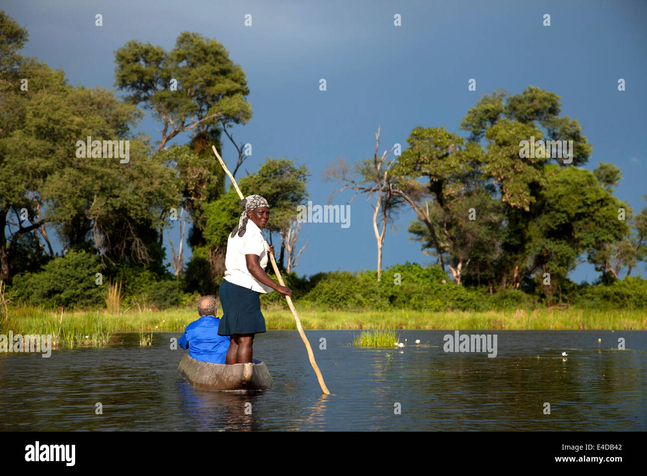 Mit Bootsführer typischer juego oder Stange und Touristen auf einem traditionellem Mokoro im Inicio del Delta del Okavango, Botswana, Afri Foto de stock