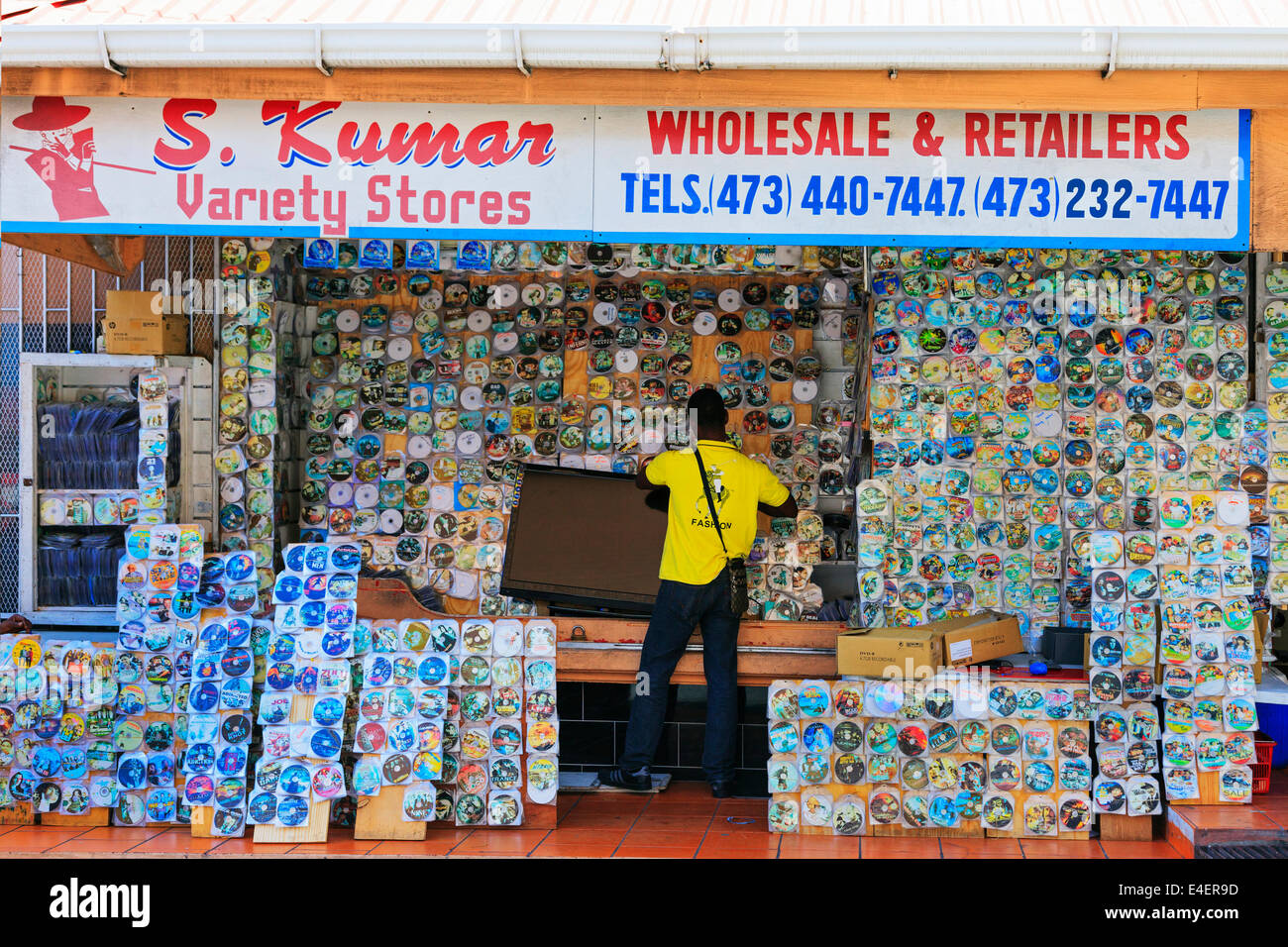 Hombre vendiendo DVDs y CDs pirateados desde una parada callejera, St George, Granada, Indias Occidentales. Foto de stock