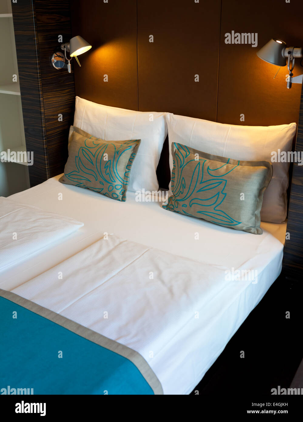 Cama doble en la habitación del hotel con luz suave Foto de stock