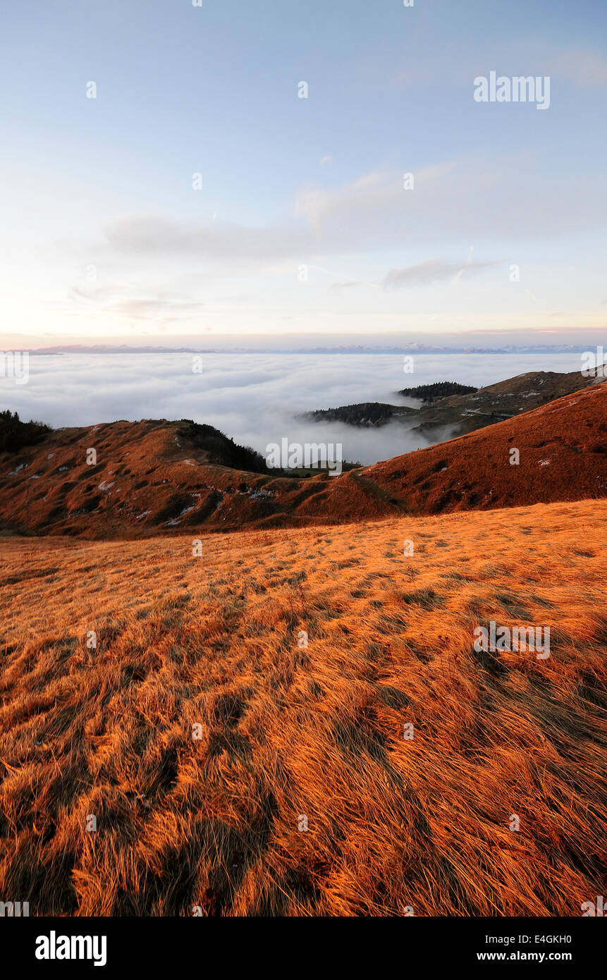 En la cima de la montaña,atardecer luz emerge de las nubes Foto de stock