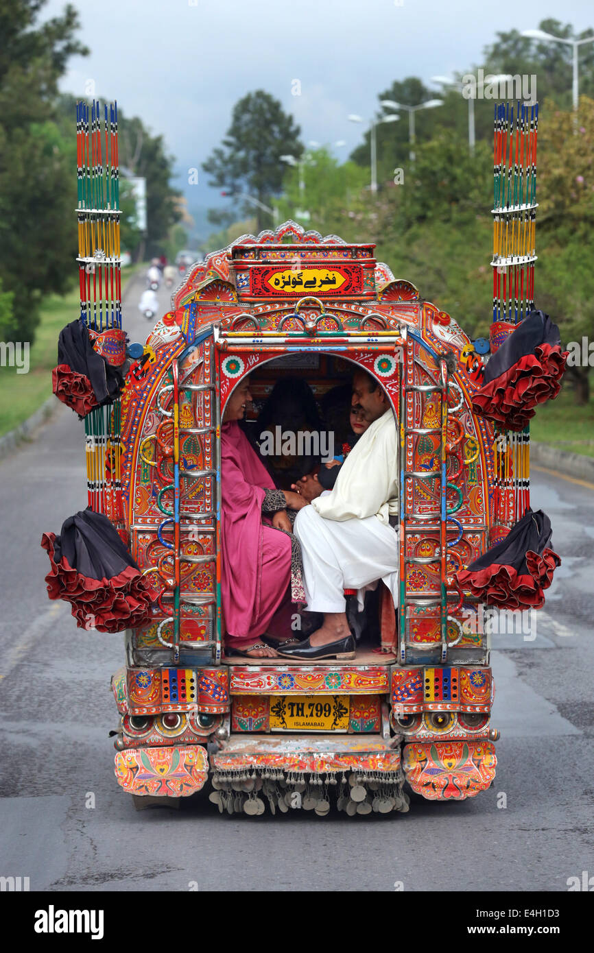Pakistán, Islamabad, pasajeros en un minibús decorado, transporte público Foto de stock