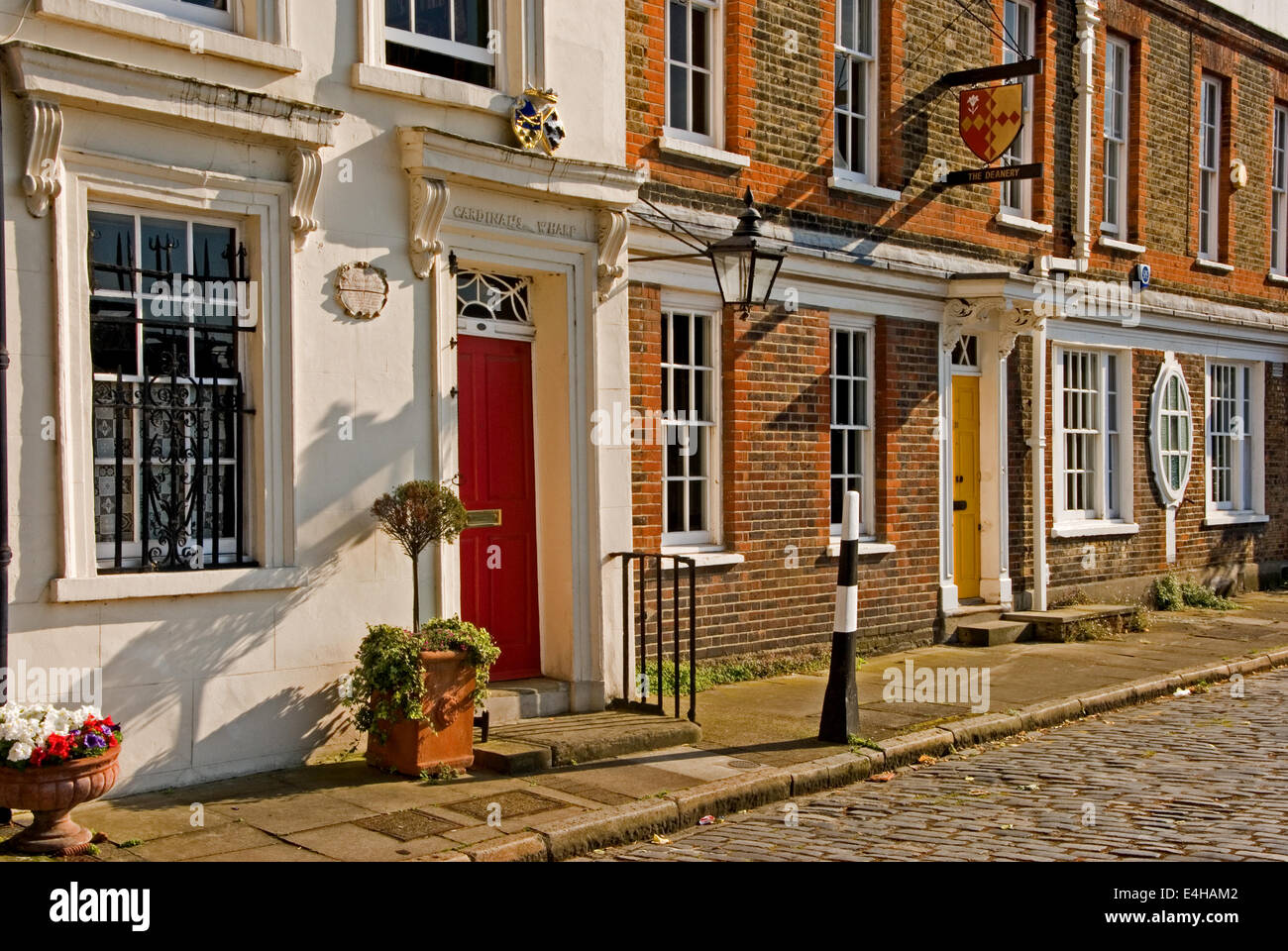 Londres adosados con calle adoquinada, bañada por el sol. Foto de stock