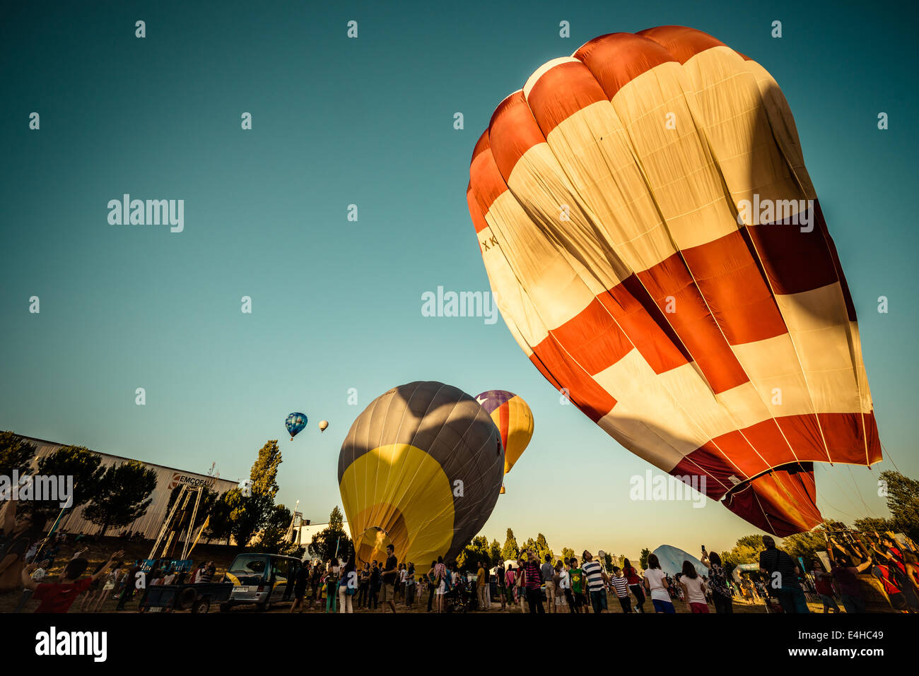 Igualada, España. Julio 10th, 2014: Ráfagas de viento deformar algunos del  globo de aire caliente envuelve a medida que tratan de preparar para la  primera noche de la competencia en el campo