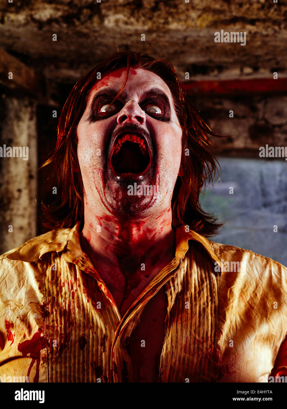 Foto de un zombie ensangrentado con su boca abierta dispuesta a morder. Foto de stock