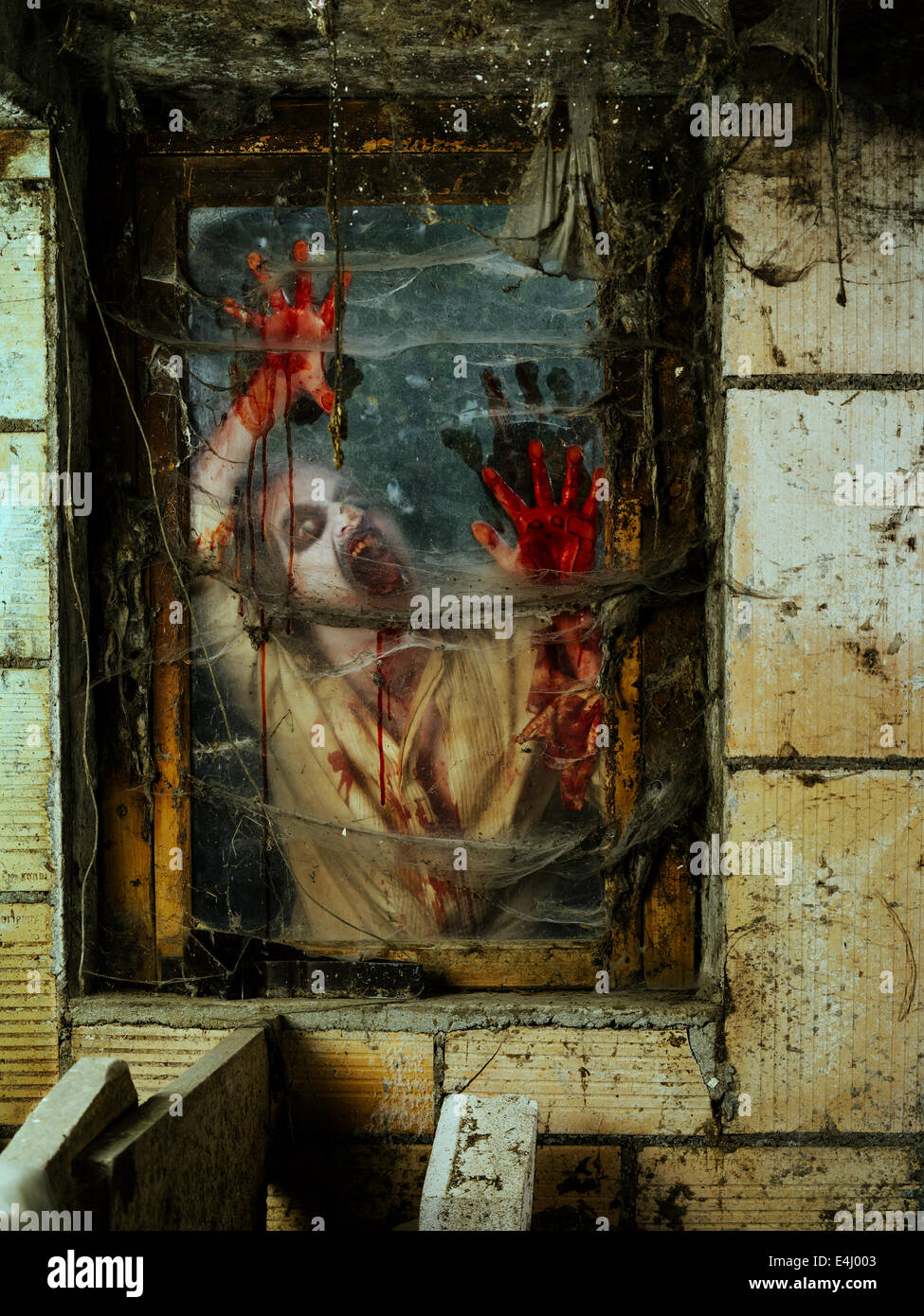 Foto de un zombie hambriento mirando a través de una ventana sucia. Foto de stock
