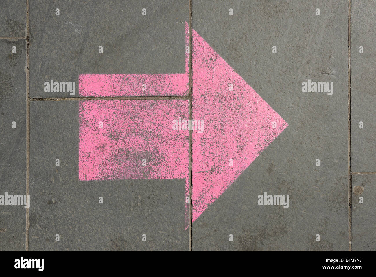 Forma de flecha pintada en el pavimento Foto de stock