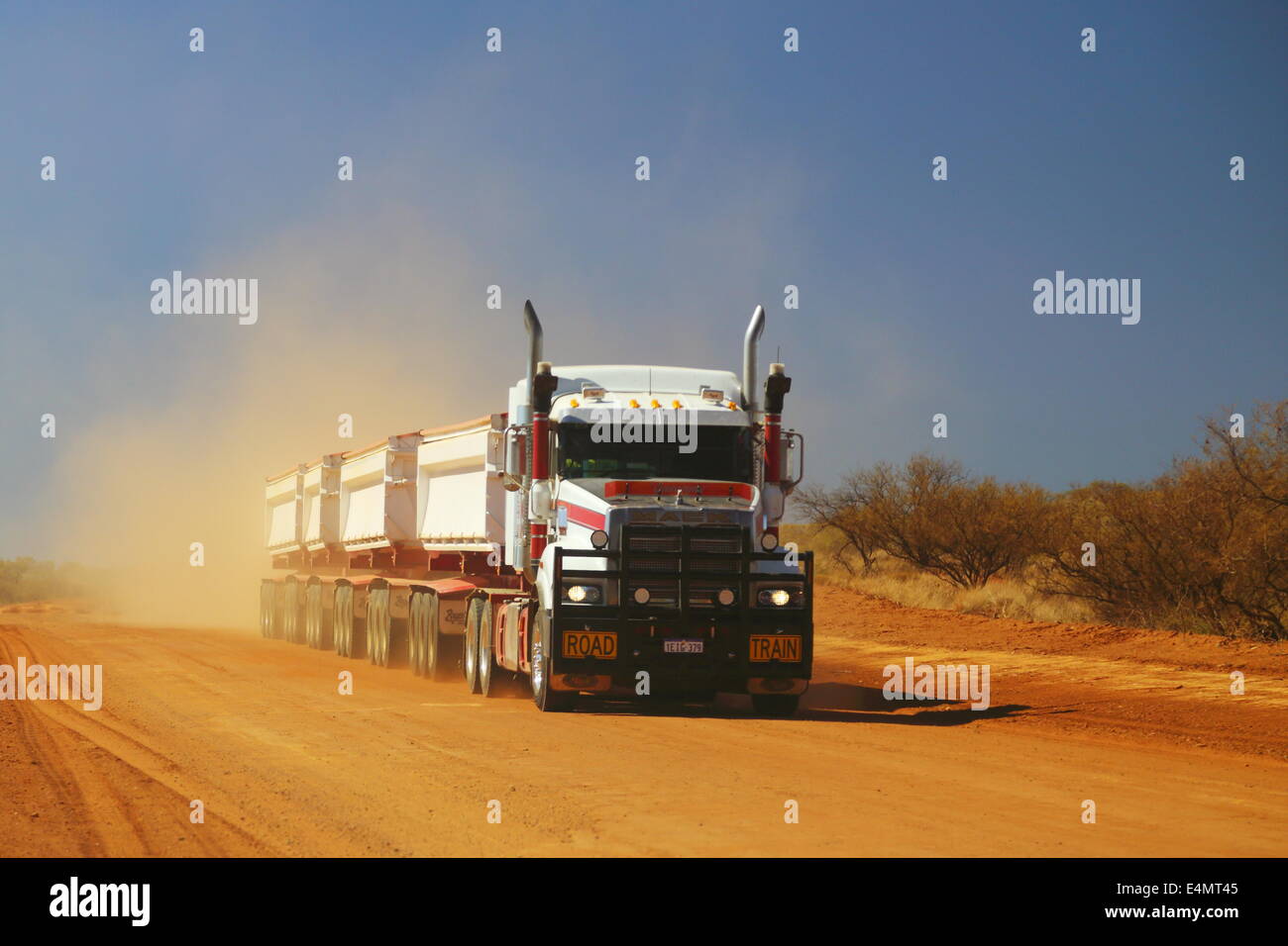 Un roadtrain carretilla transporta una carga a lo largo de un polvoriento camino de tierra en el oeste de Australia. Foto de stock