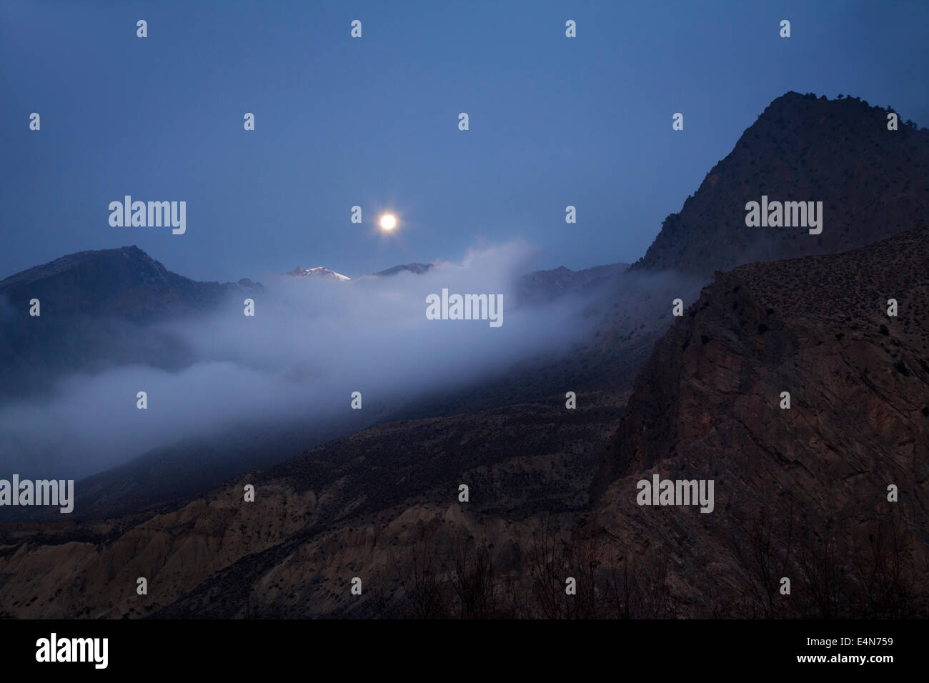 La luna y las montañas en Jomsom, distrito de Mustang, Himalaya, Nepal Foto de stock