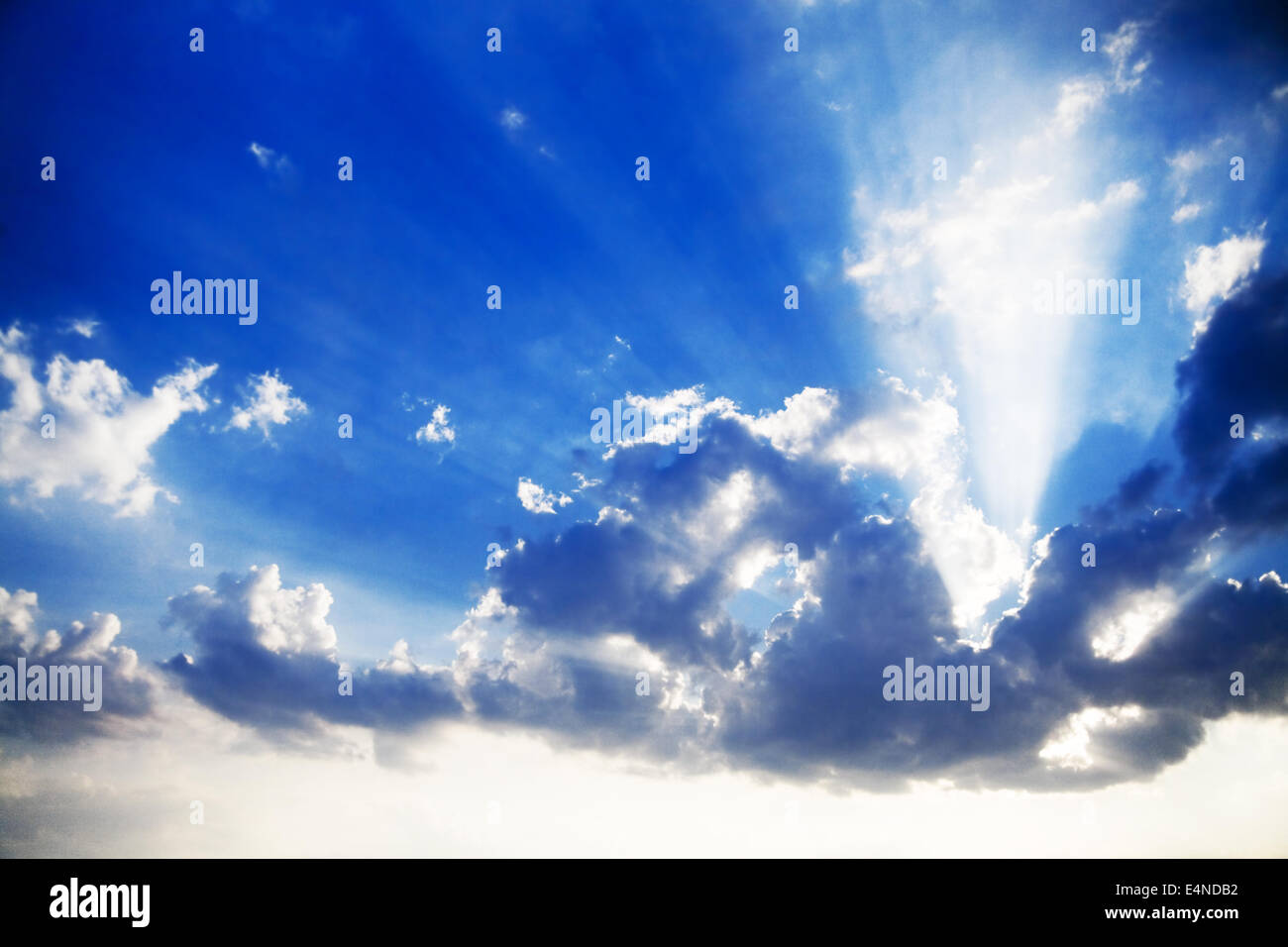 Azul cielo nublado y brillantes rayos de sol Foto de stock