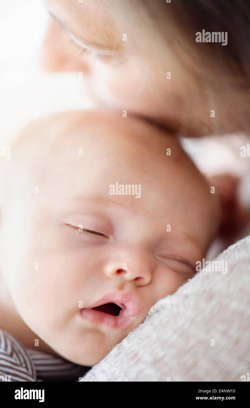 Cerca de Baby Boy (2-5 meses) dormir sobre el hombro de la madre Foto de stock