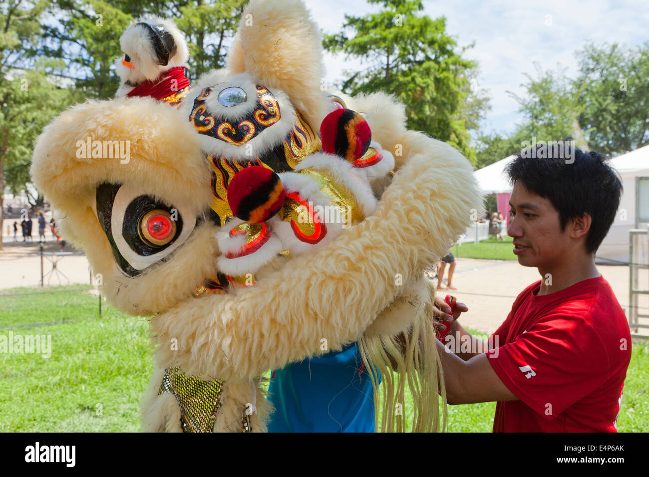 Hombre ayudando a una bailarina poniendo en traje de León al festival chino - EE.UU. Foto de stock