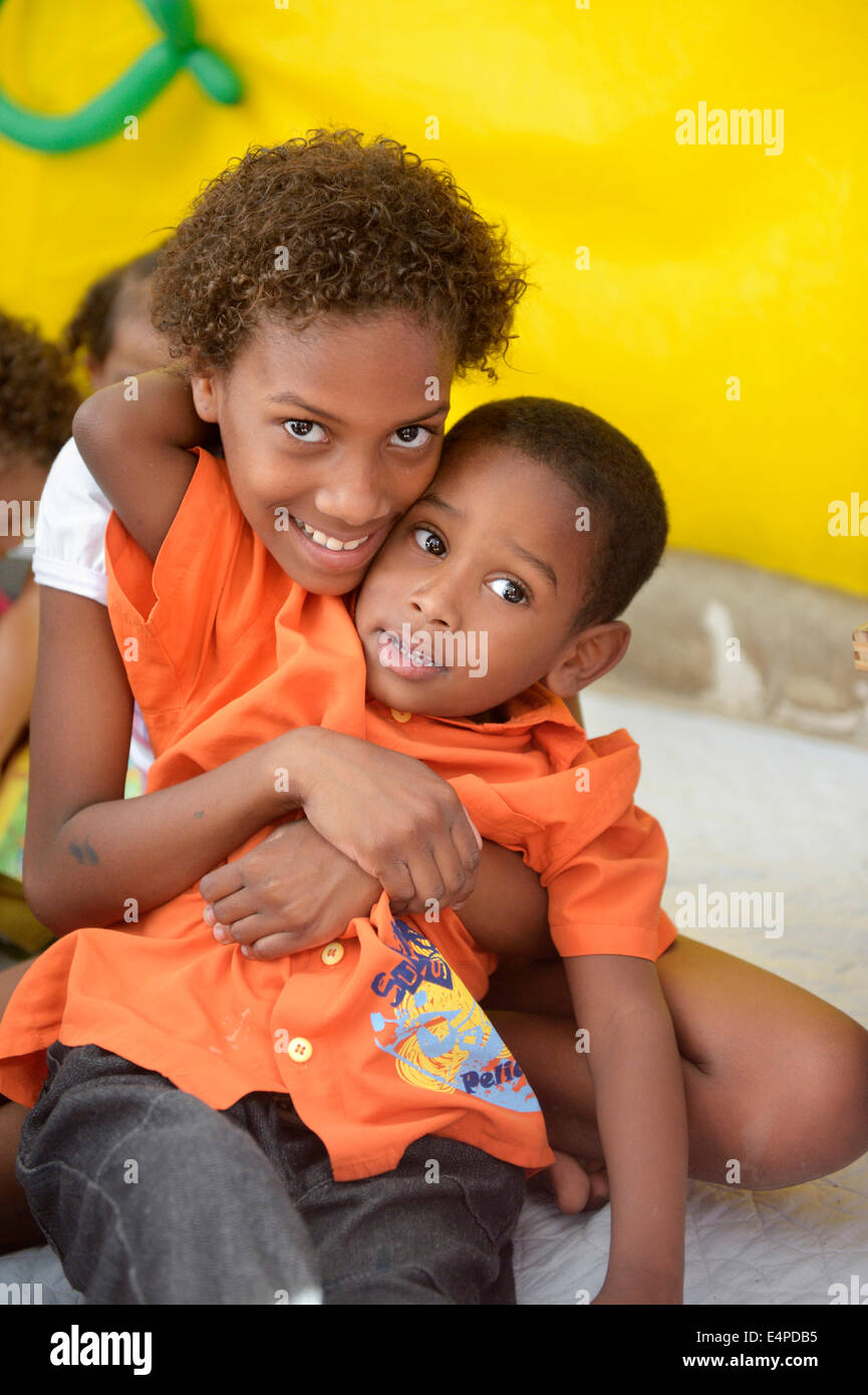 Niña de 9 años, y el muchacho, 6 años, abrazando a todos los demás, el kindergarten de un proyecto social, los barrios, Mangueirinha favela Foto de stock