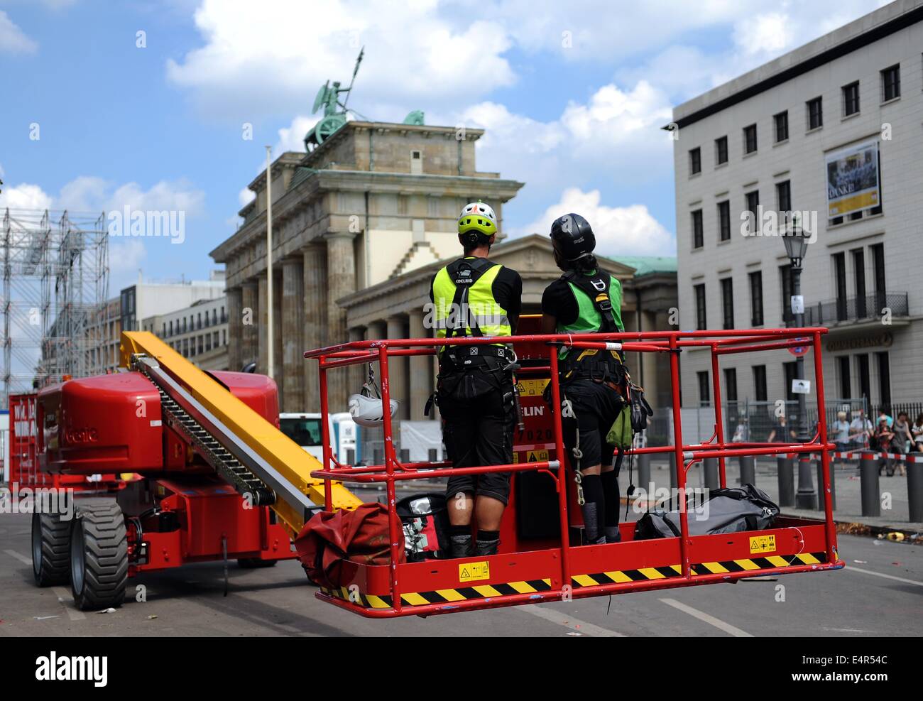 Los trabajadores desmontar el escenario en el "trasse des 17. Juni" delante de la Puerta de Brandenburgo en Berlín, Alemania, el 16 de julio de 2014. Durante el período de duración de la Copa del Mundo de 2014, los llamados "Fan Meile" fue el sitio central para el público Fan Fests que se celebraron durante los partidos de la Copa del Mundo de 2014. Foto: Britta Pedersen/dpa Foto de stock