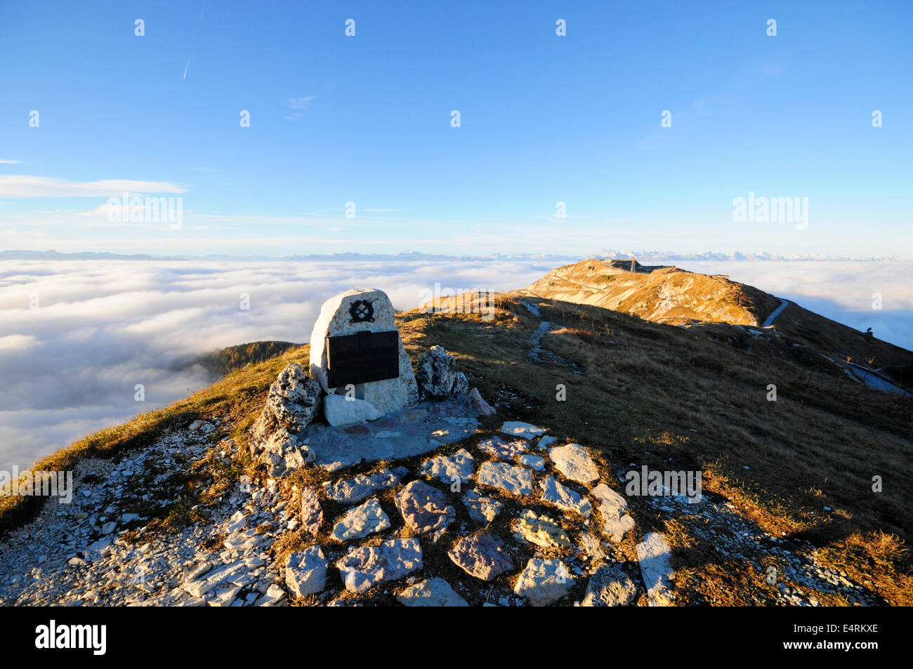 Monumento militar en la cima de una montaña con una luz que emerge de las nubes Foto de stock