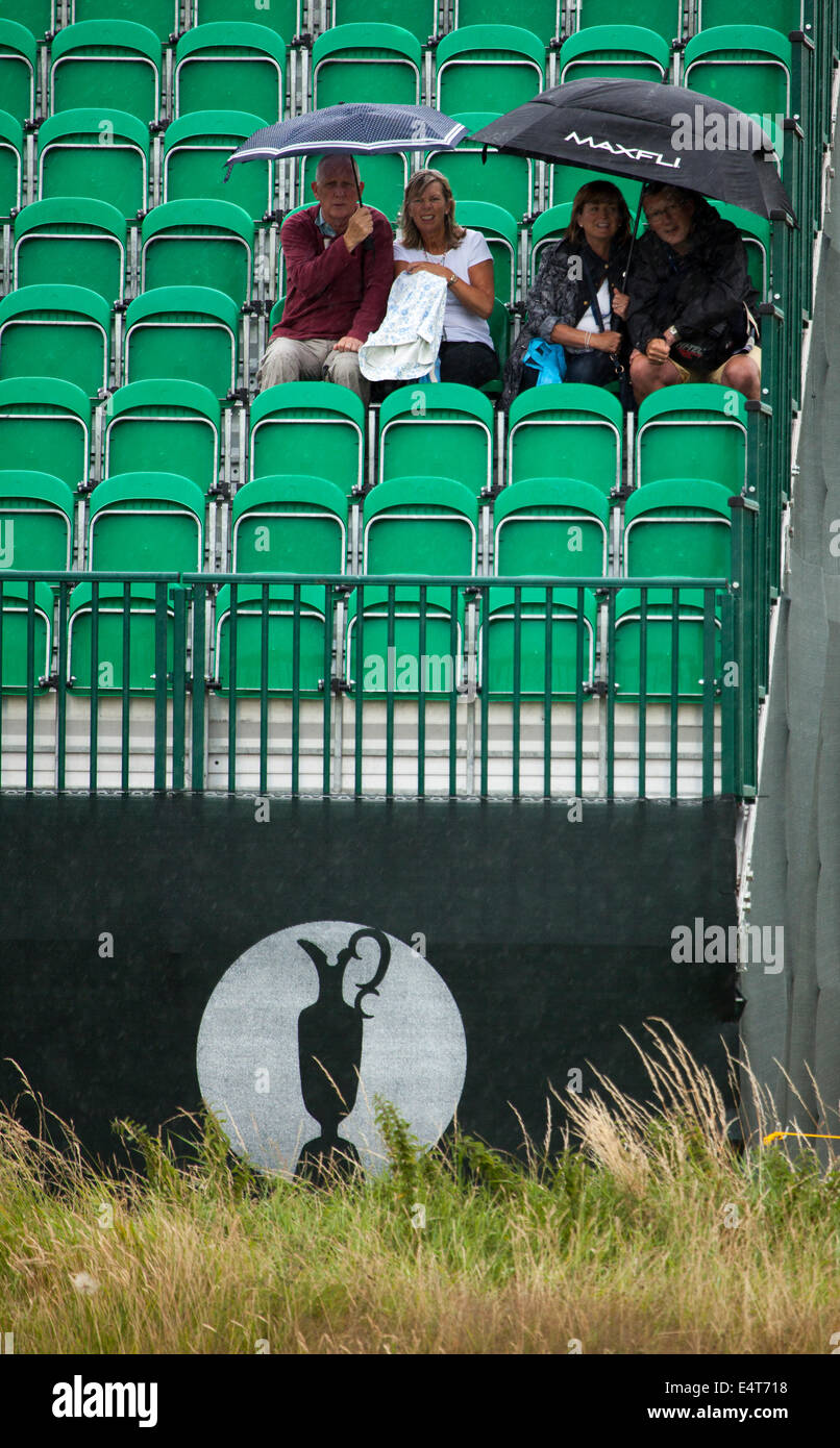 Los espectadores sentados bajo las sombrillas en uno de los British Open de Golf se sitúa en el Royal Liverpool Golf para el British Open 2014 Como llueve Foto de stock