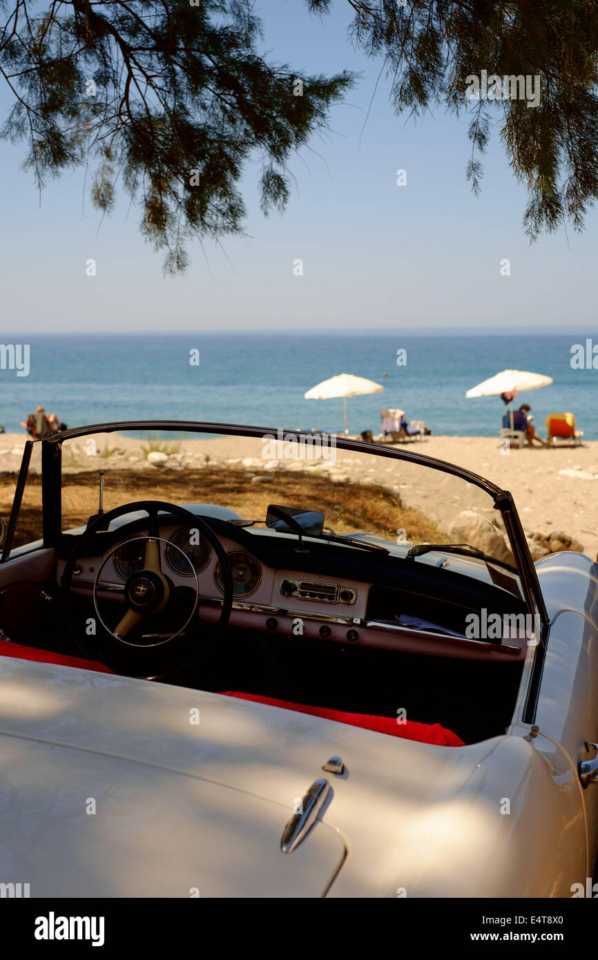 Classic open top convertible Alfa Romeo blanco coche deportivo - estacionado en una playa - Península de Mani, Peloponeso, Grecia Foto de stock