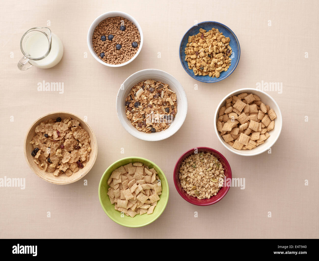 Vista aérea de cuencos de una variedad de cereales saludables y la jarra de leche, Foto de estudio Foto de stock