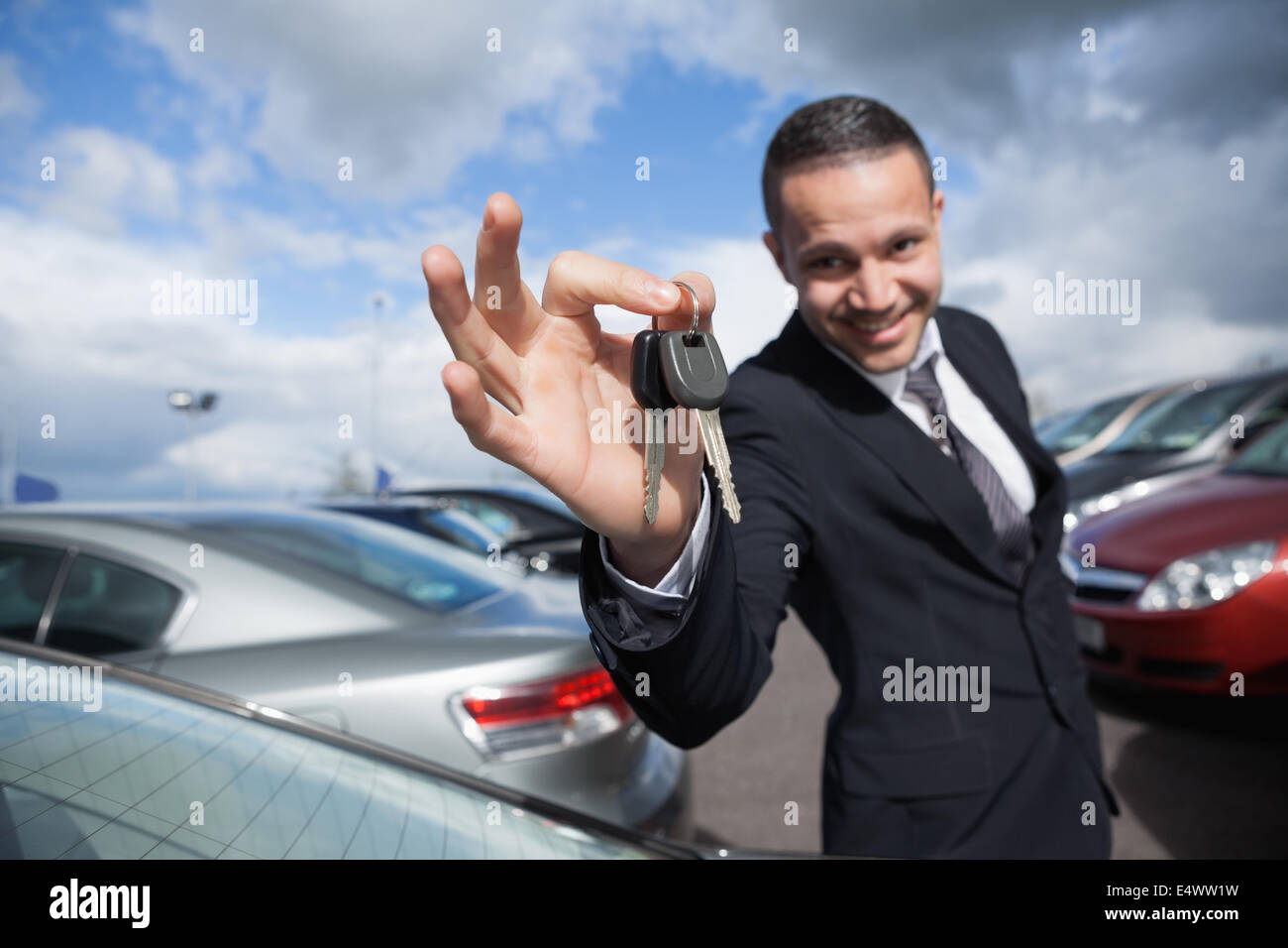Concesionario feliz sosteniendo las llaves del coche Foto de stock