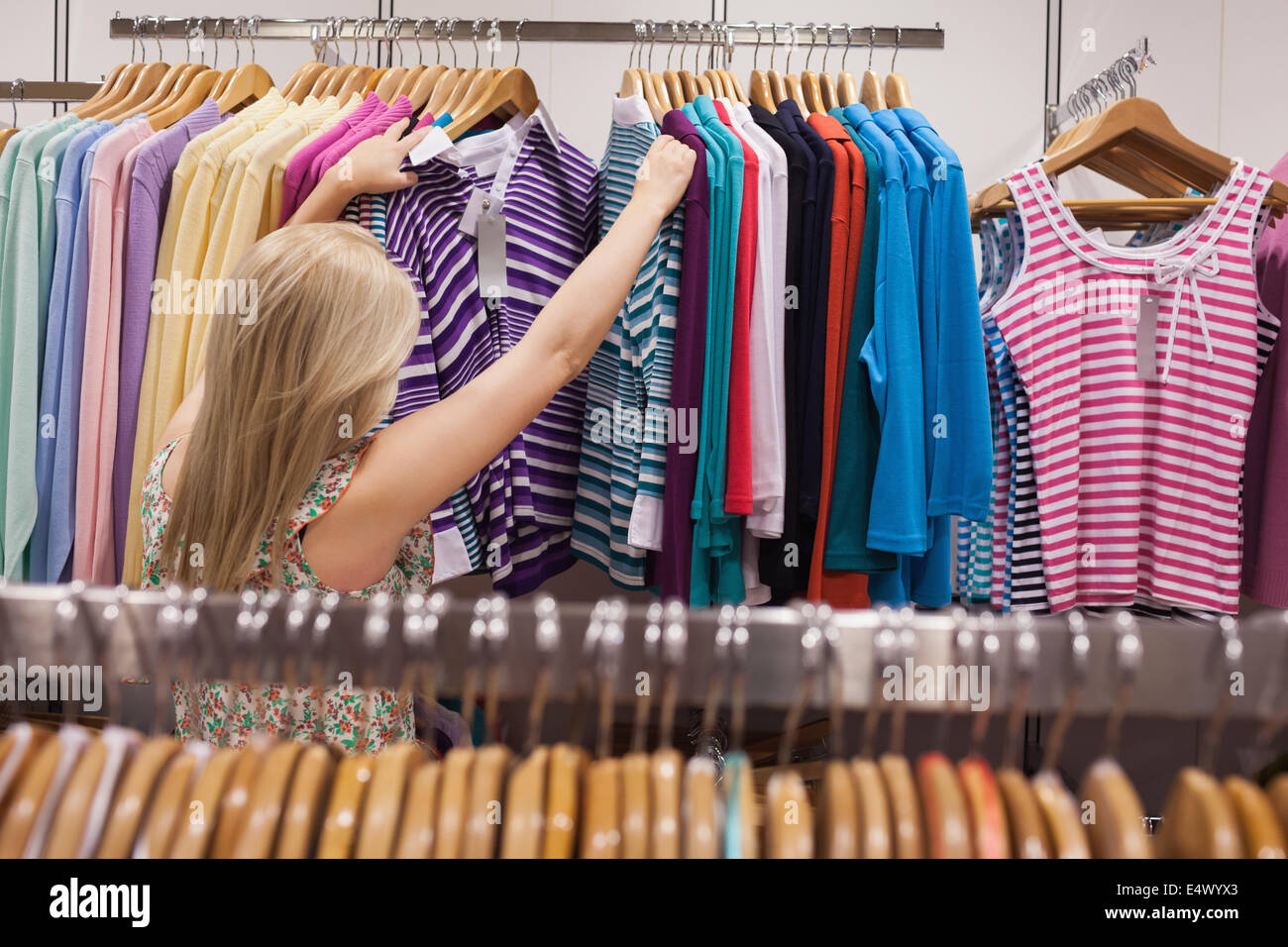 Mujer busca ropa en el perchero Fotografía de stock - Alamy