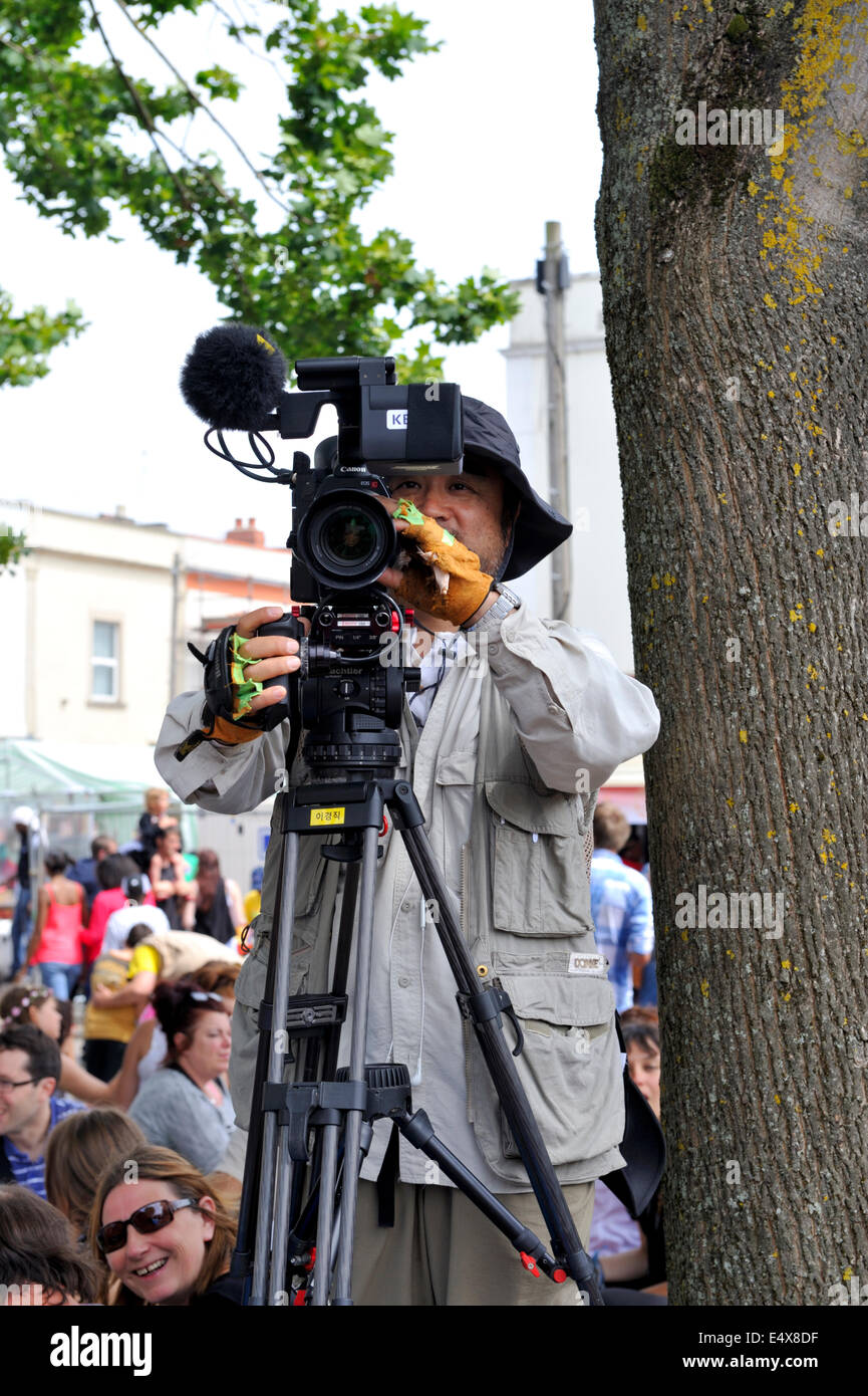 Hombre filmar con una cámara Canon eos en Bristol St Paul's street festival, REINO UNIDO Foto de stock