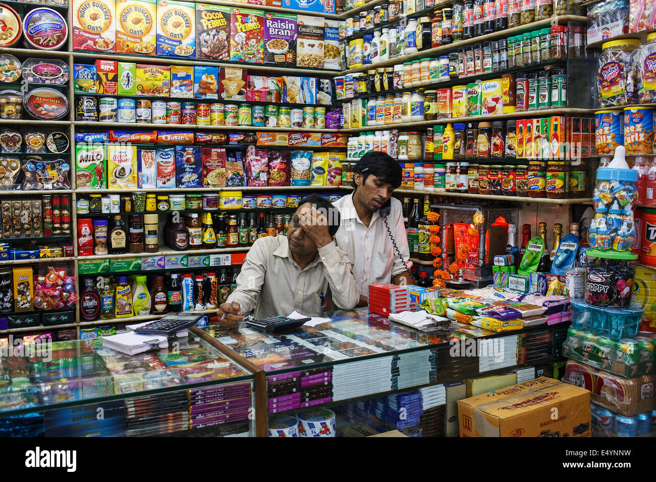 Los tenderos en su tienda de comestibles en el mercado Crawford en Mumbai, India. Foto de stock