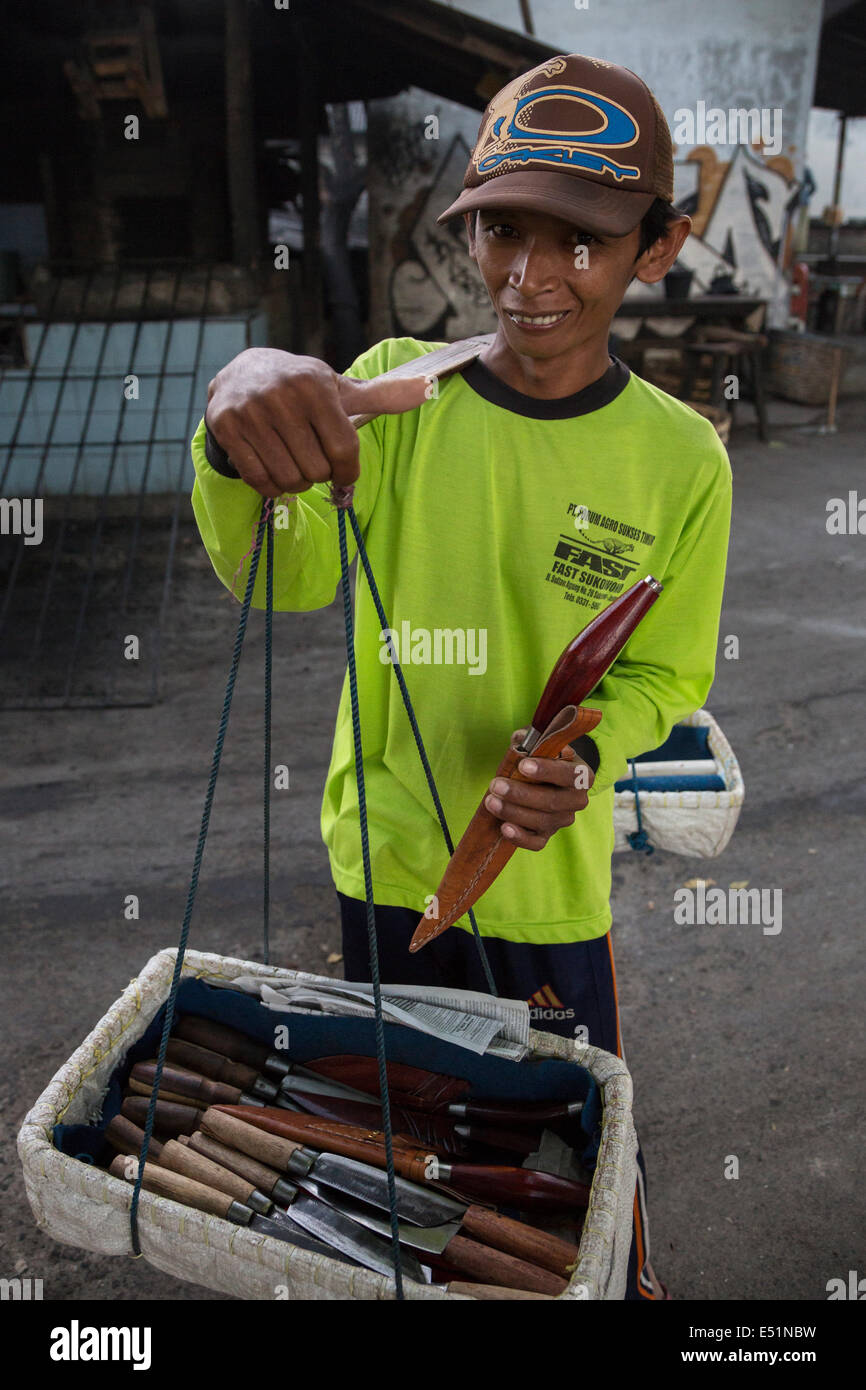Bali, Indonesia. Joven vendedor ambulante de venta de cuchillos y fundas, fuera del mercado de Jimbaran. Foto de stock