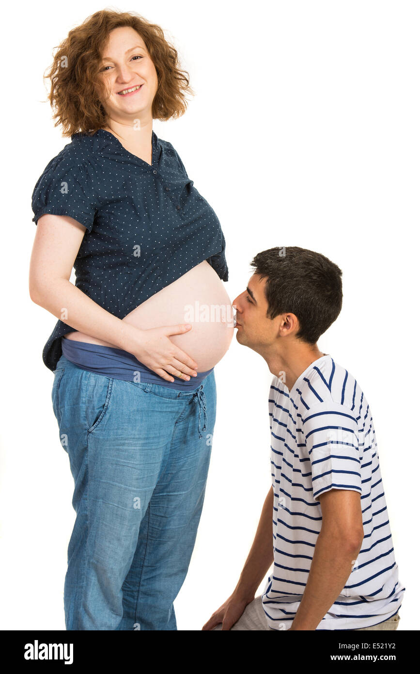 Futuro padre besar embarazada vientre aislado sobre fondo blanco. Foto de stock