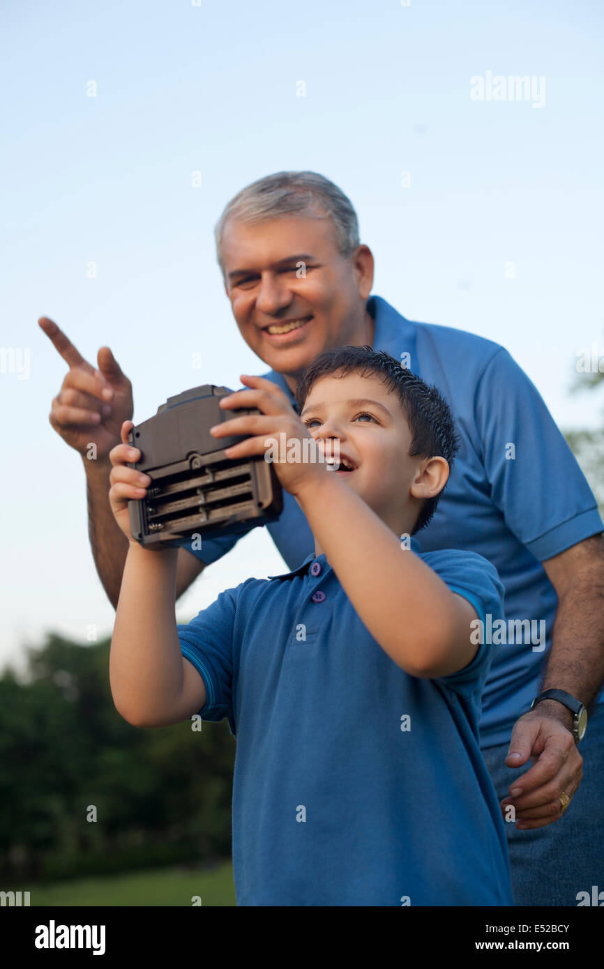 El abuelo y el muchacho jugando con Radio Controlado auricular Foto de stock