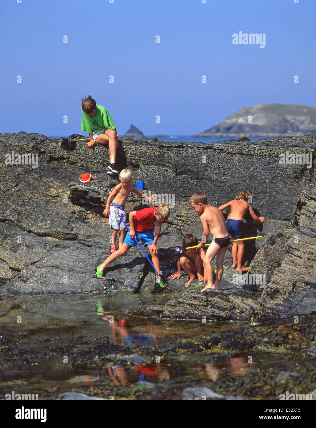 Los niños la pesca en roca en la piscina de la playa, Cornwall, Inglaterra, Reino Unido Foto de stock