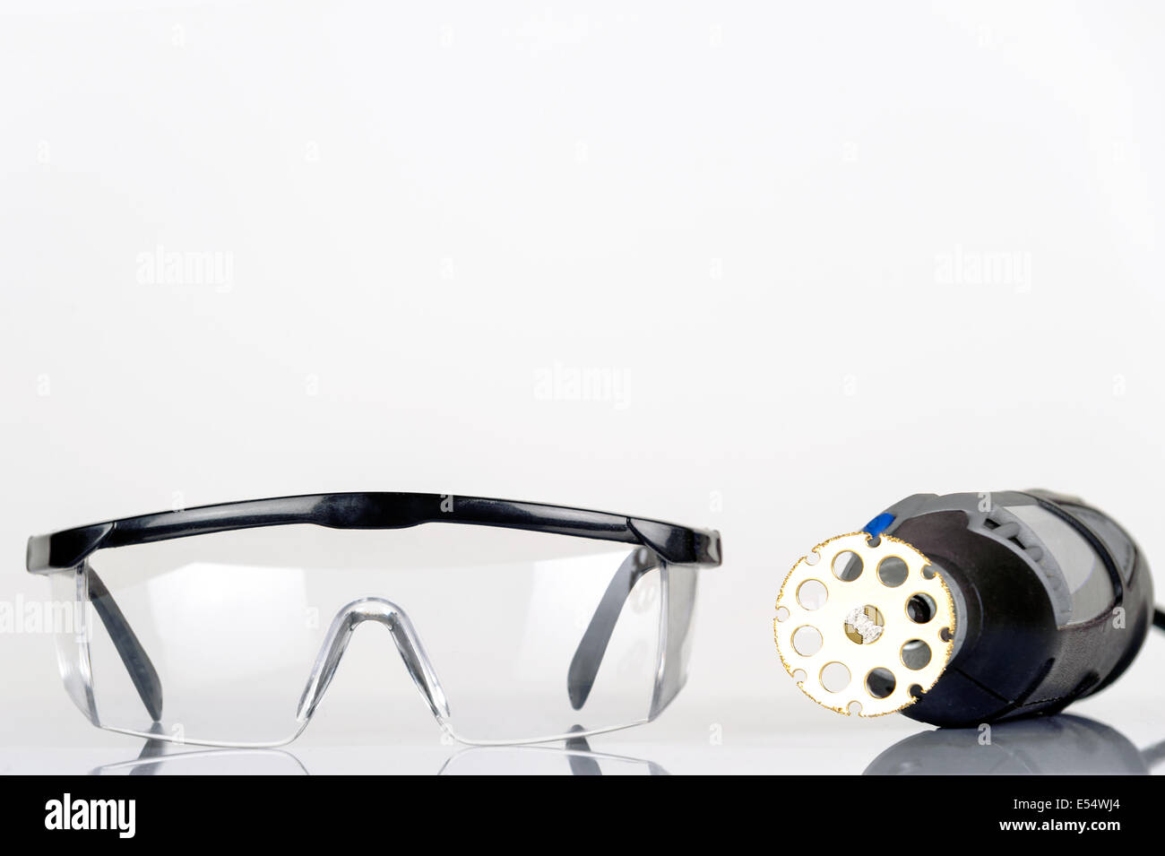 Pequeña herramienta rotatoria con sierra accesorio y gafas de seguridad,  aislado Fotografía de stock - Alamy