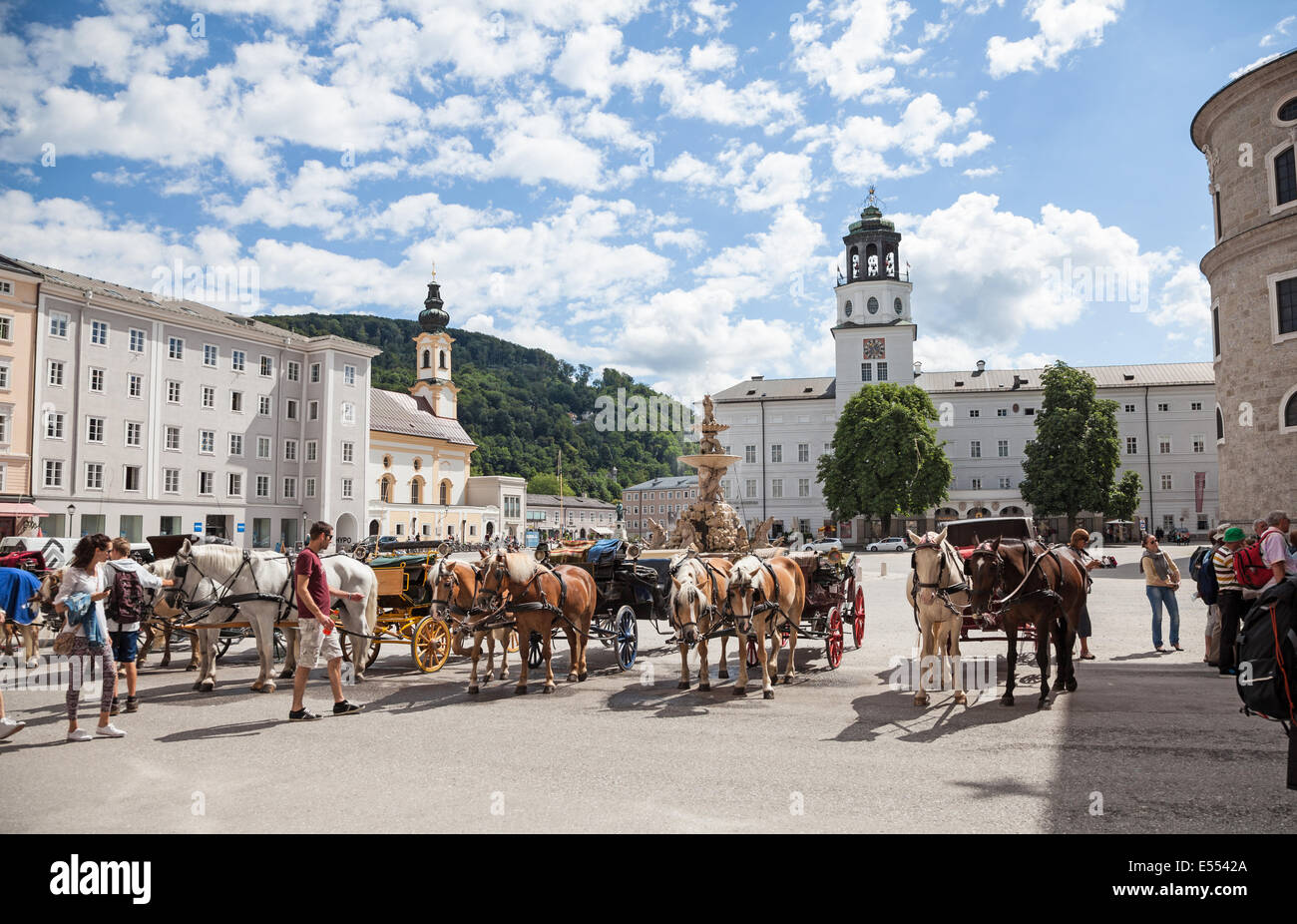 Fiacres, una calesa de carro de cuatro ruedas, y sus conductores, a la espera de ser contratados Residenzplatz Salzburgo Austria Europa Foto de stock